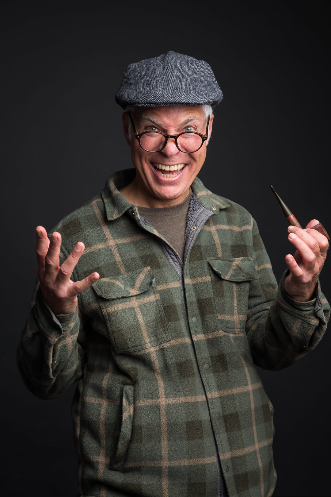 Steve Budd in flannel shirt and pageboy cap holding a pipe