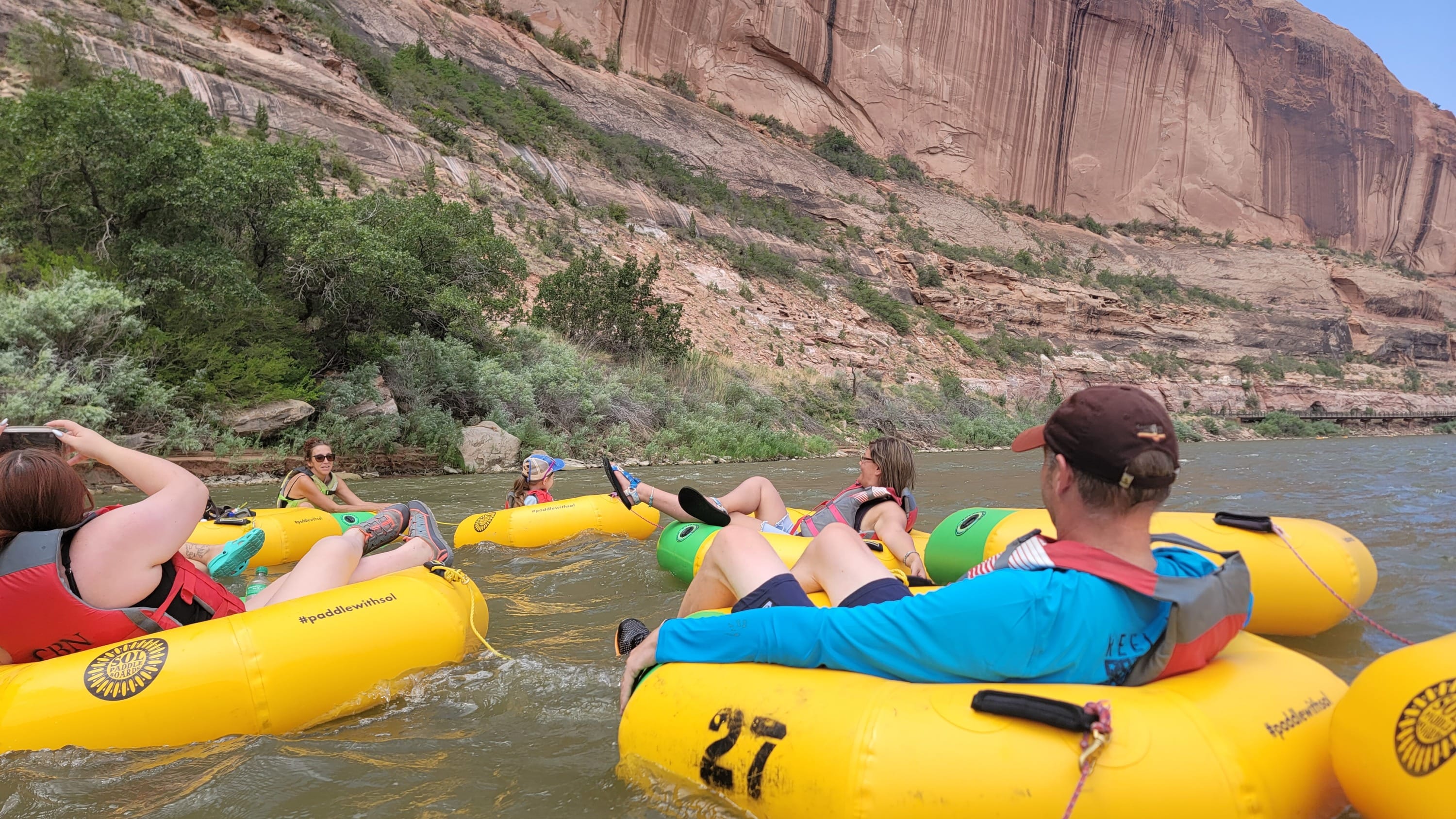 Tubers relaxing with drinks in hand on a sunny day in southern Utah