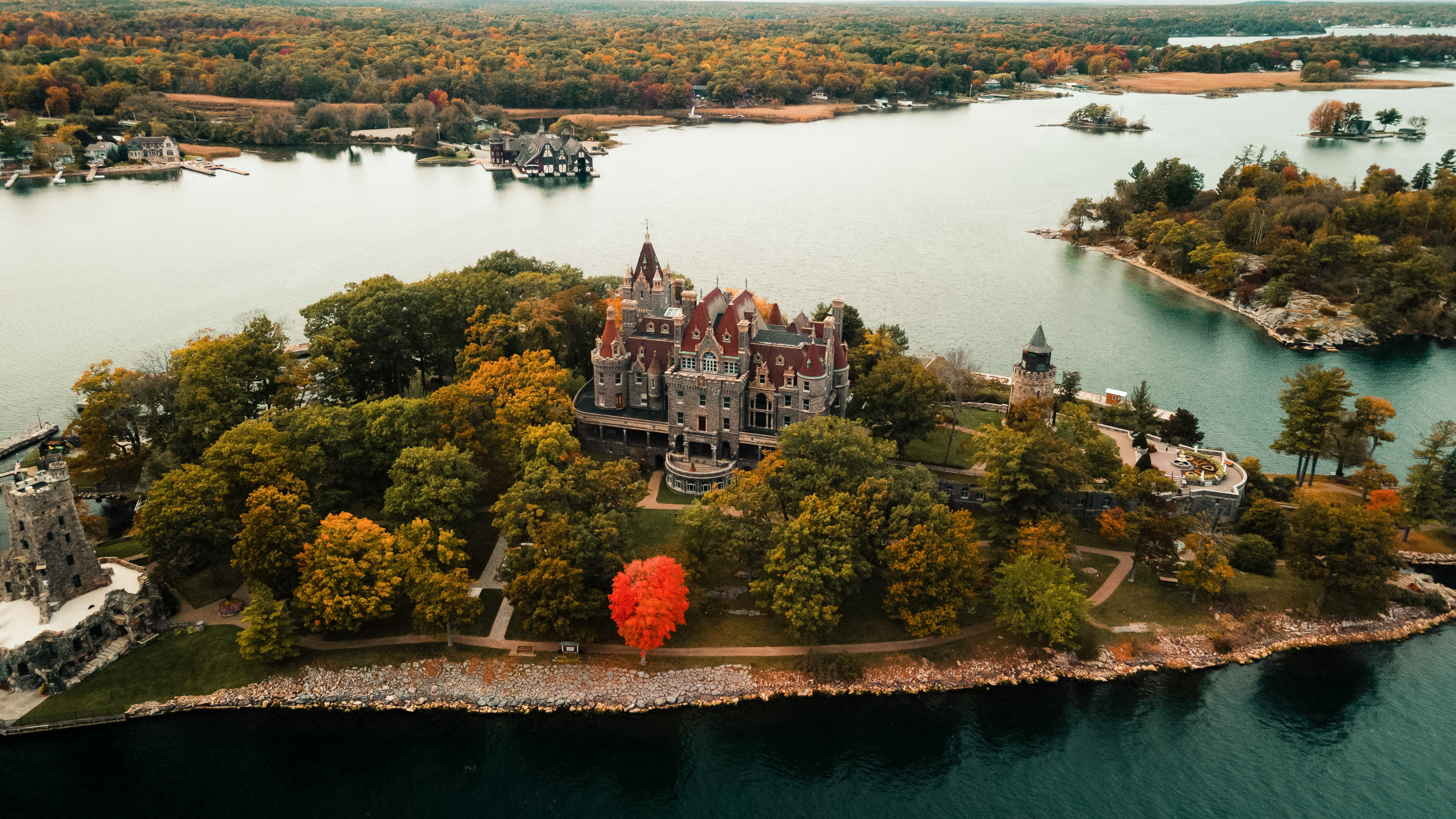 Ariel image of Boldt Castle on Heart Island in the fall. The yacht house is in the background of the image