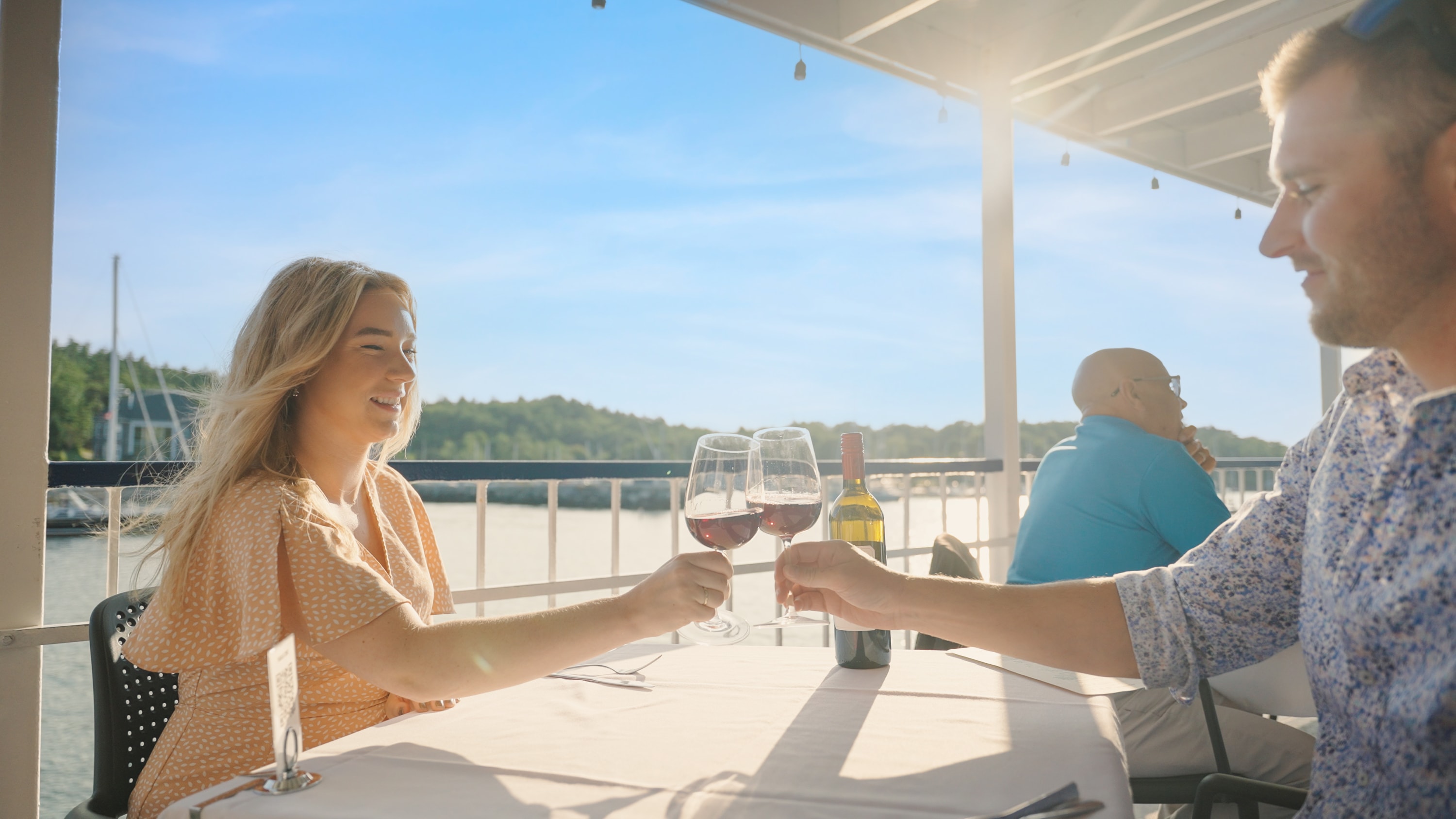 A couple clink glasses while on the Dinner Cruise aboard Harbour Queen