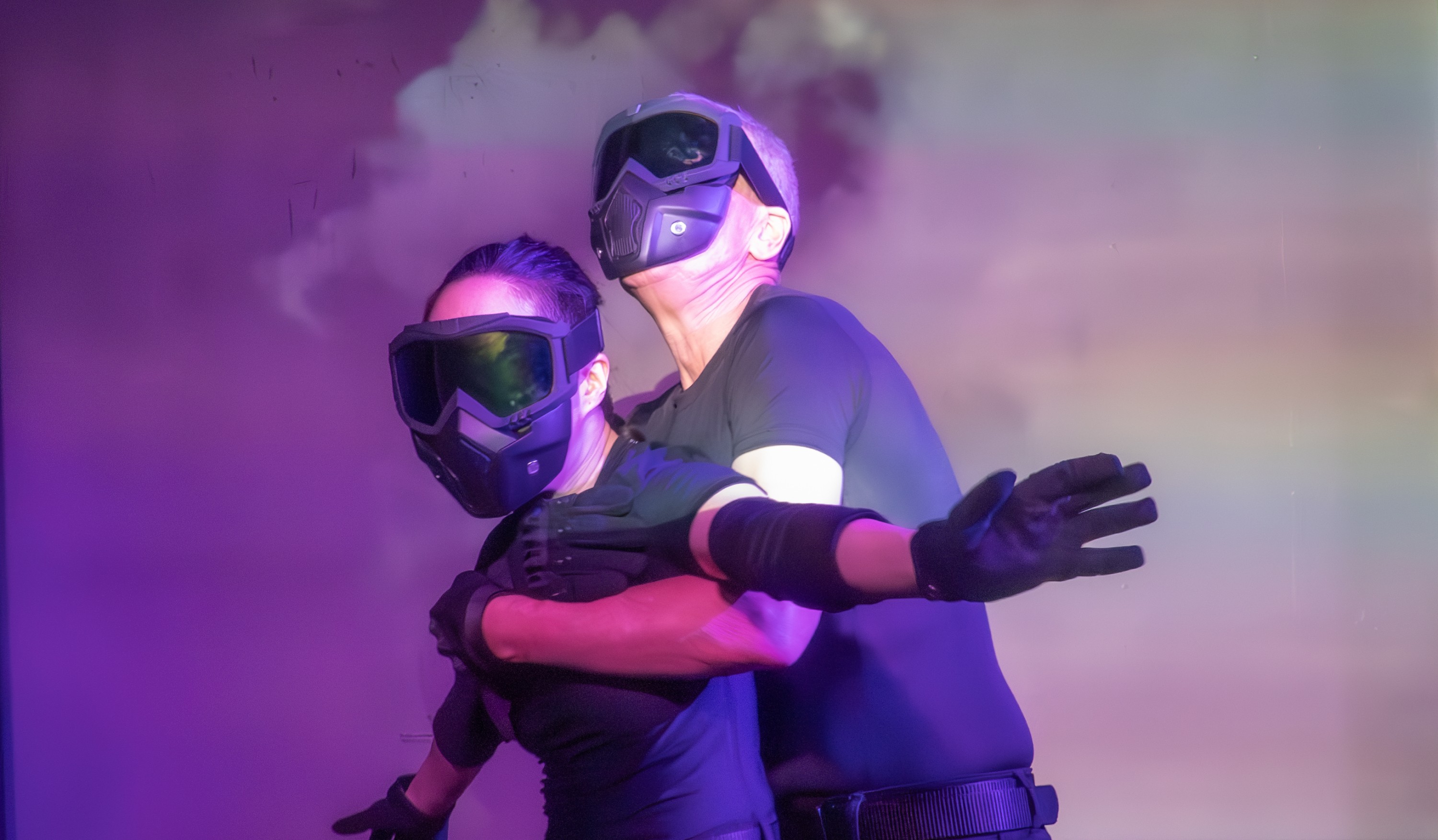 two actors in spy masks and heist clothing holding each other