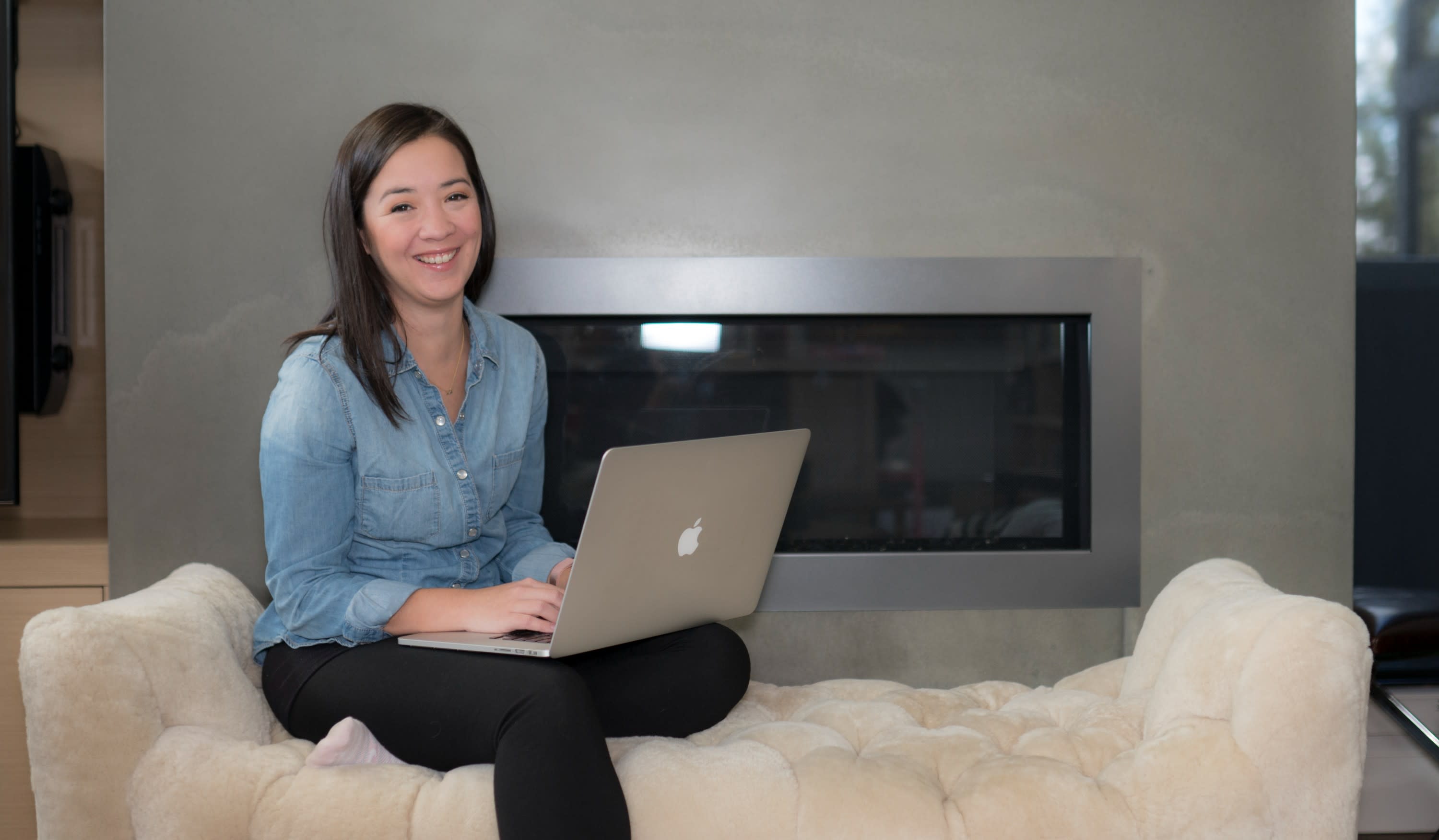 Sami sitting on a couch holding a laptop