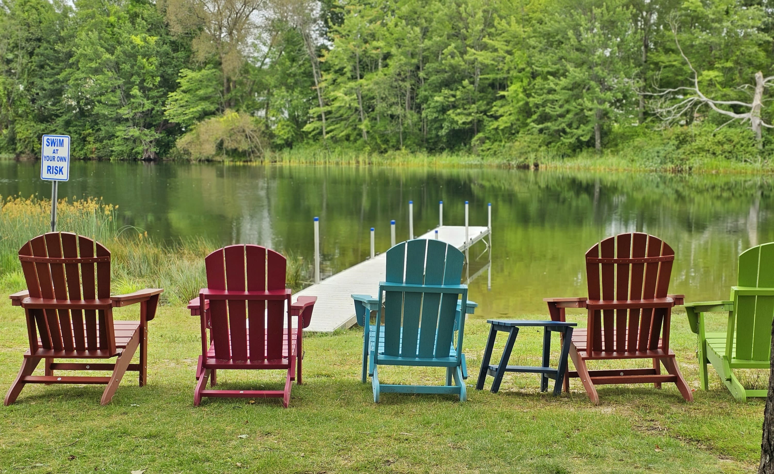 Photo of Adirondack chairs beside the Lake Auburn outlet in Lake Grove Park