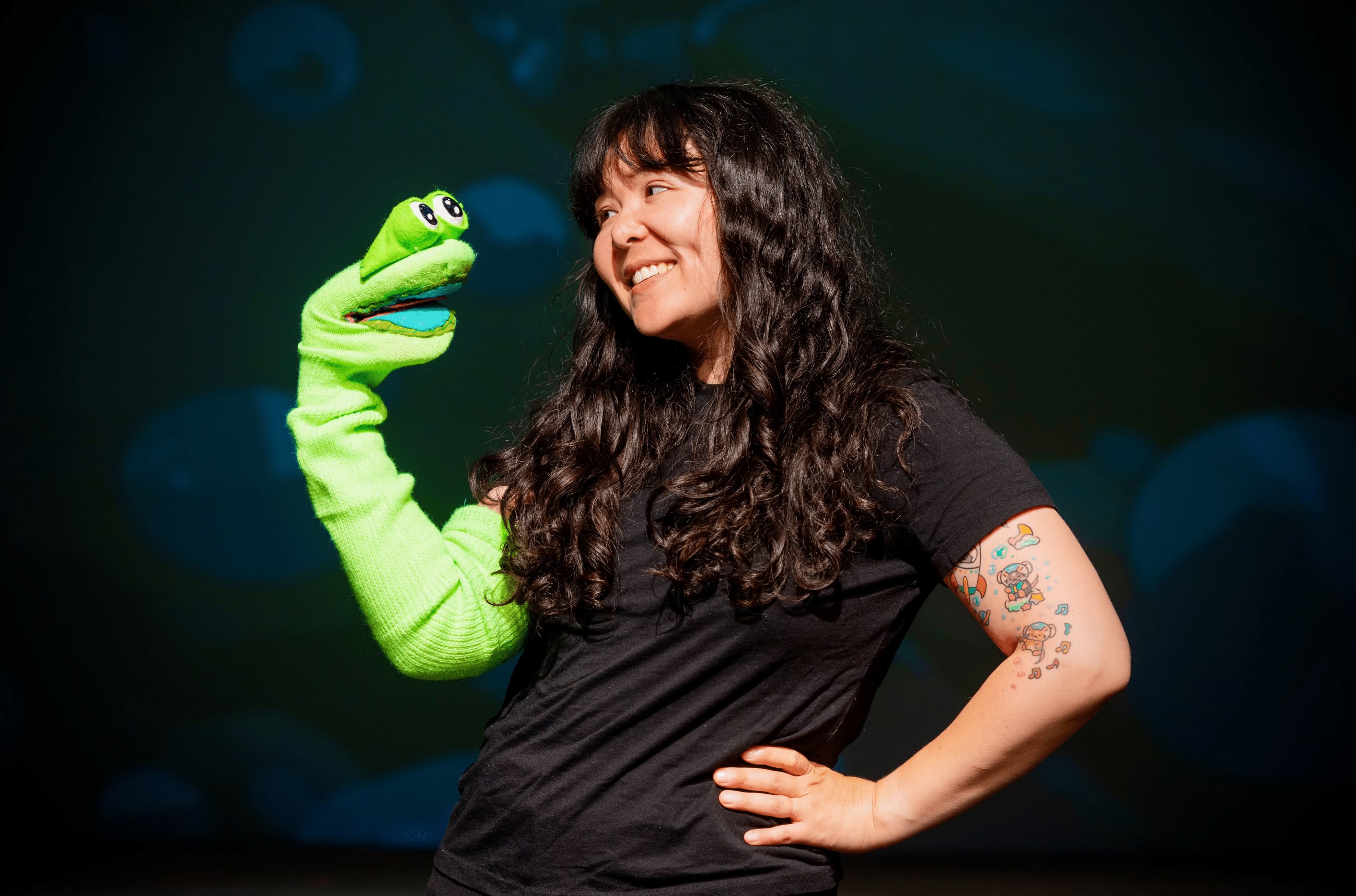 actor with a bright green eel puppet smiling