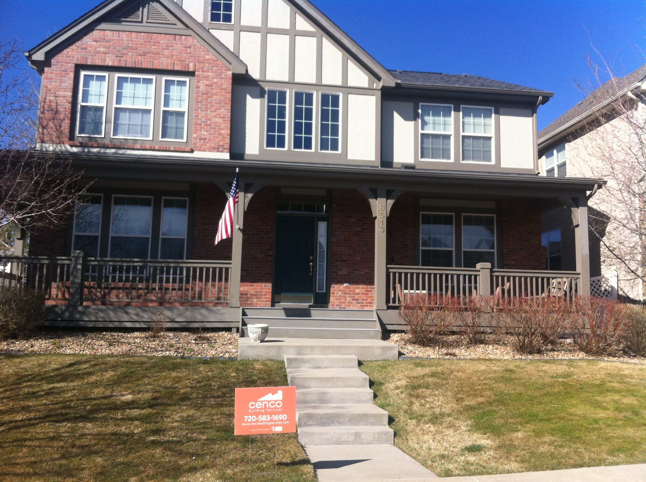 house with new roof and a Cenco Roofing sign in the yard