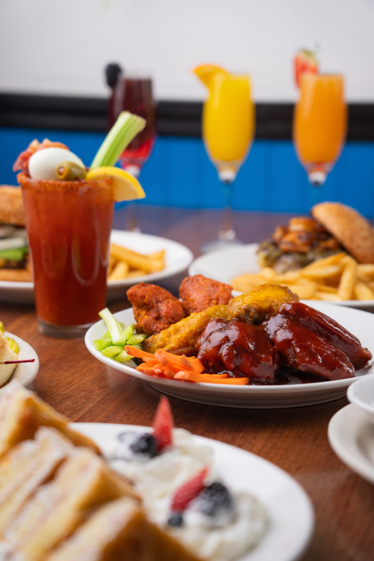 Miley’s Cafe brunch spread with saucy chicken wings, fries, burgers, and colorful brunch cocktails at a cozy table