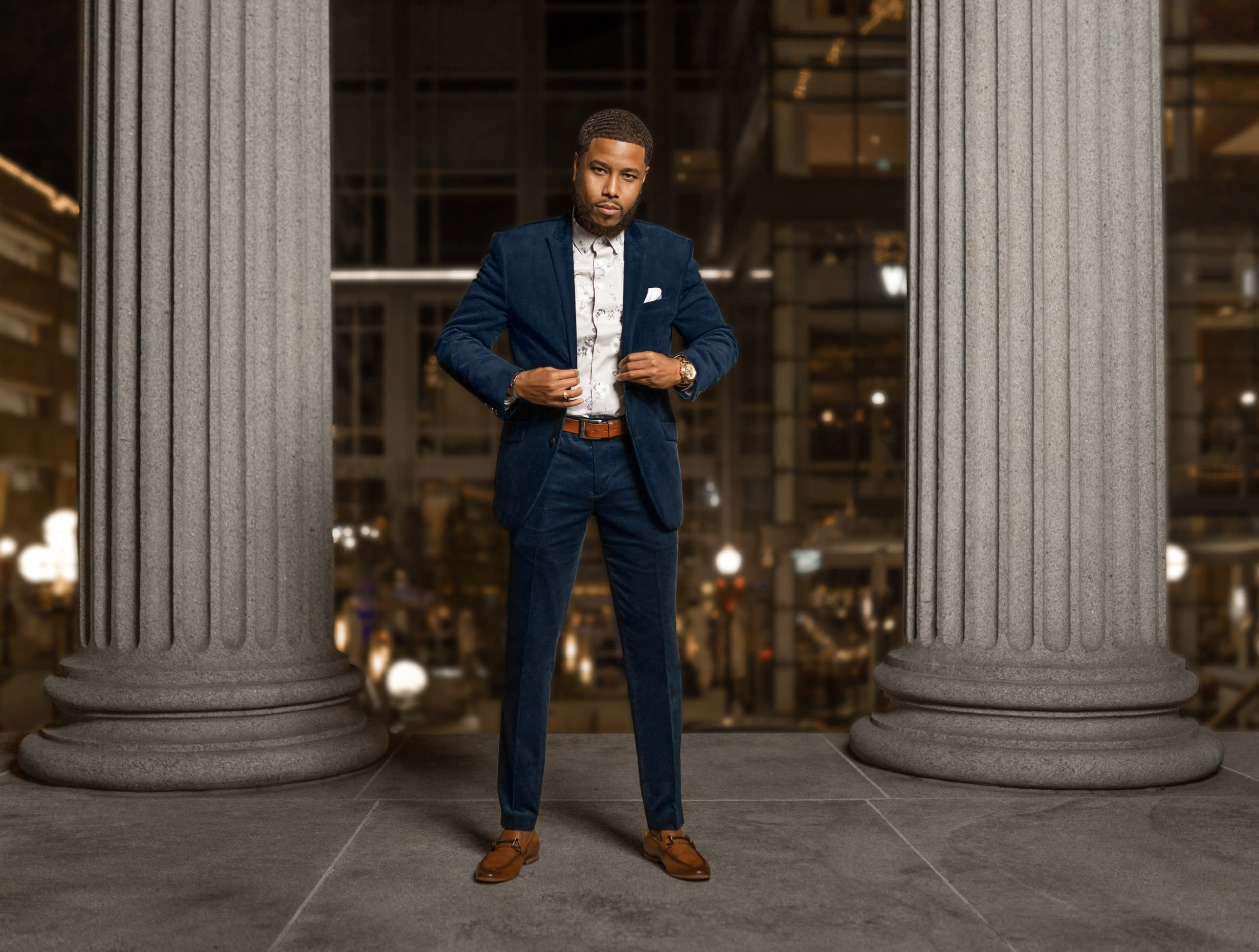 black in blue suit near columns outside