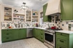 A green and cream kitchen in a modern Arts & Crafts style.