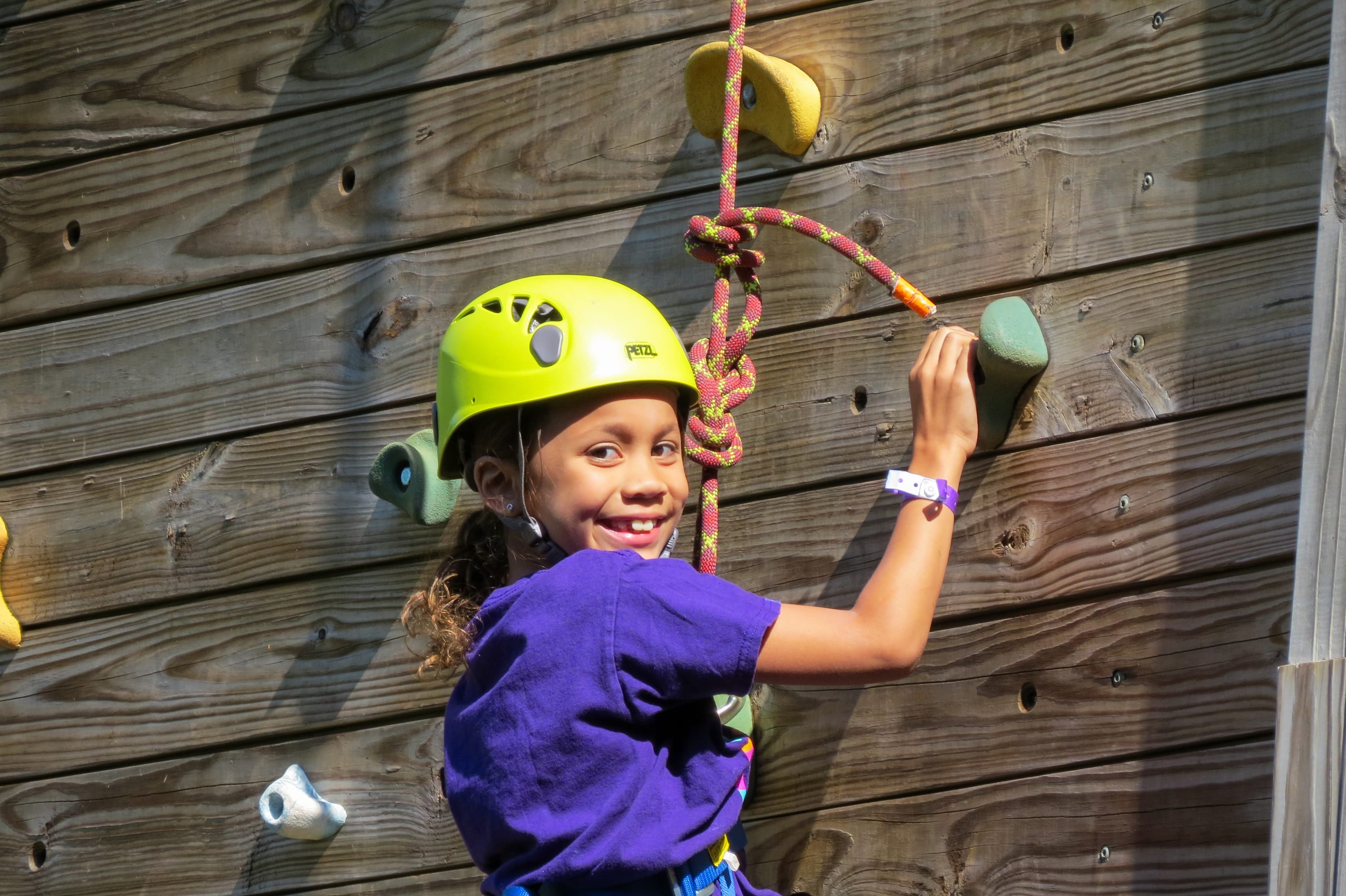 Photo of girl wearing protective gear rock climbing at Girl Scouts of Western Ohio