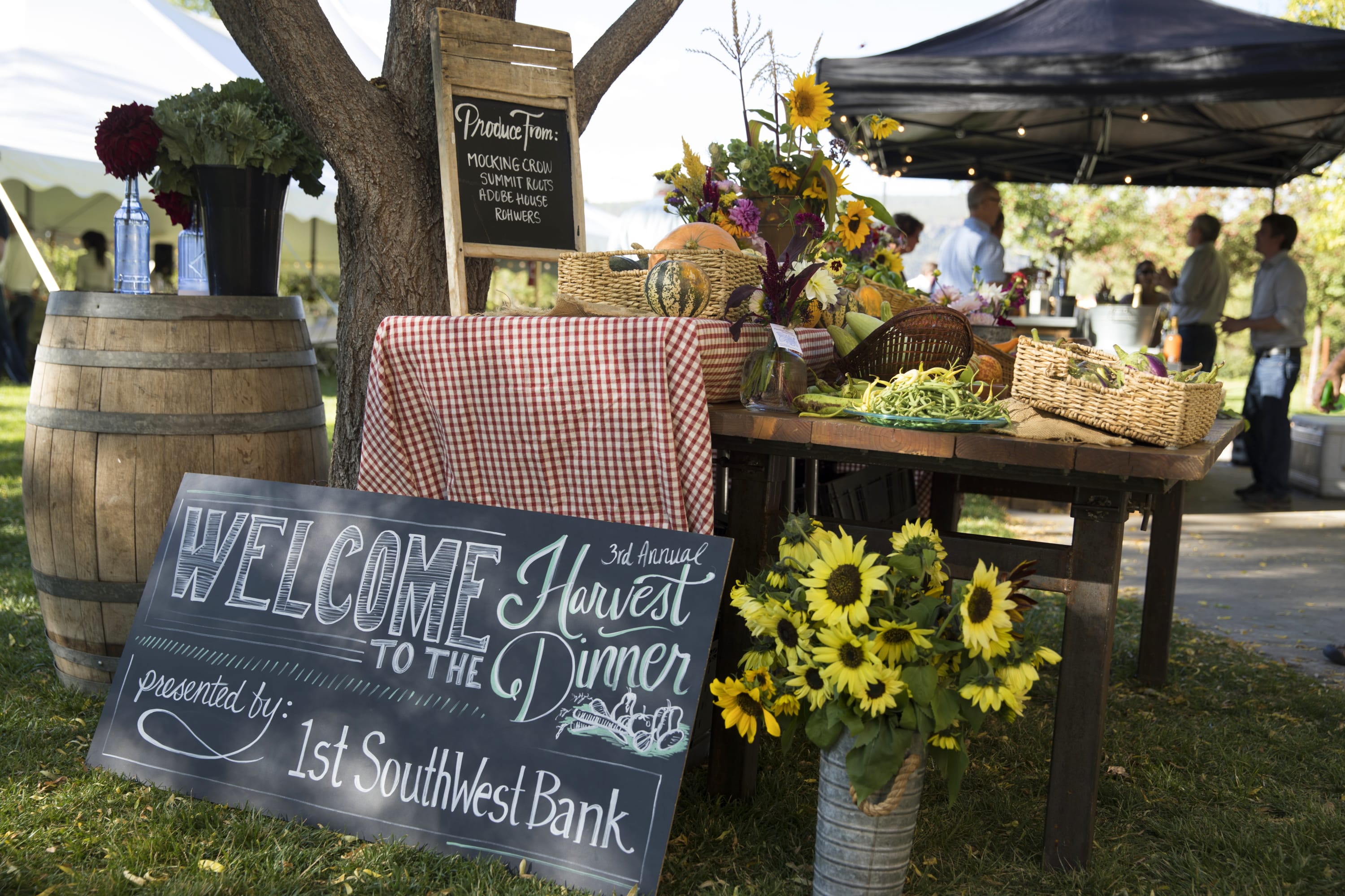 Photograph of tablescape with sign reading "Welcome to the 3rd Annual Harvest Dinner Presented by 1st SouthWest Bank".