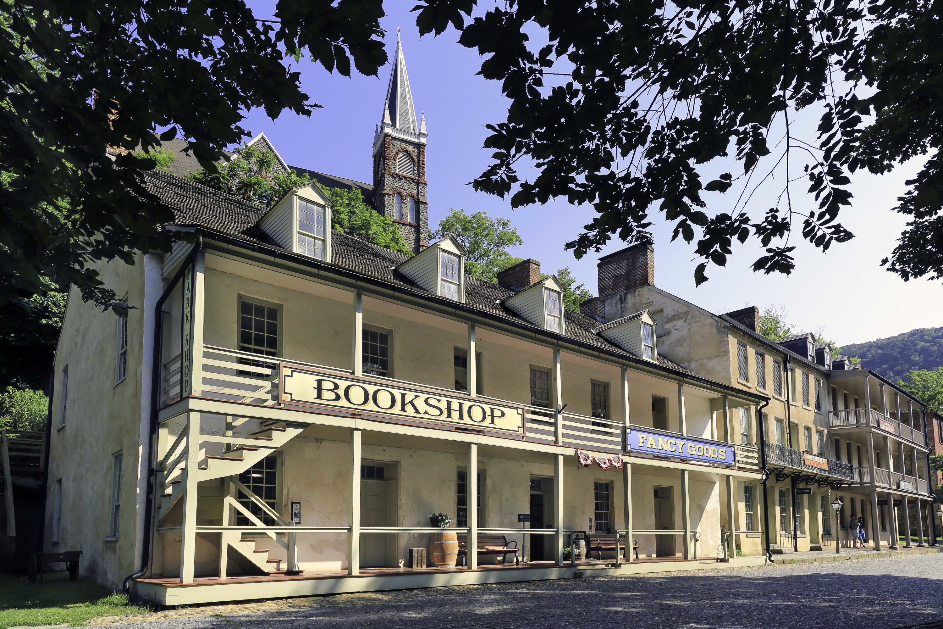 Exterior view of the Park Bookshop framed by tree branches and a blue sky in the background.