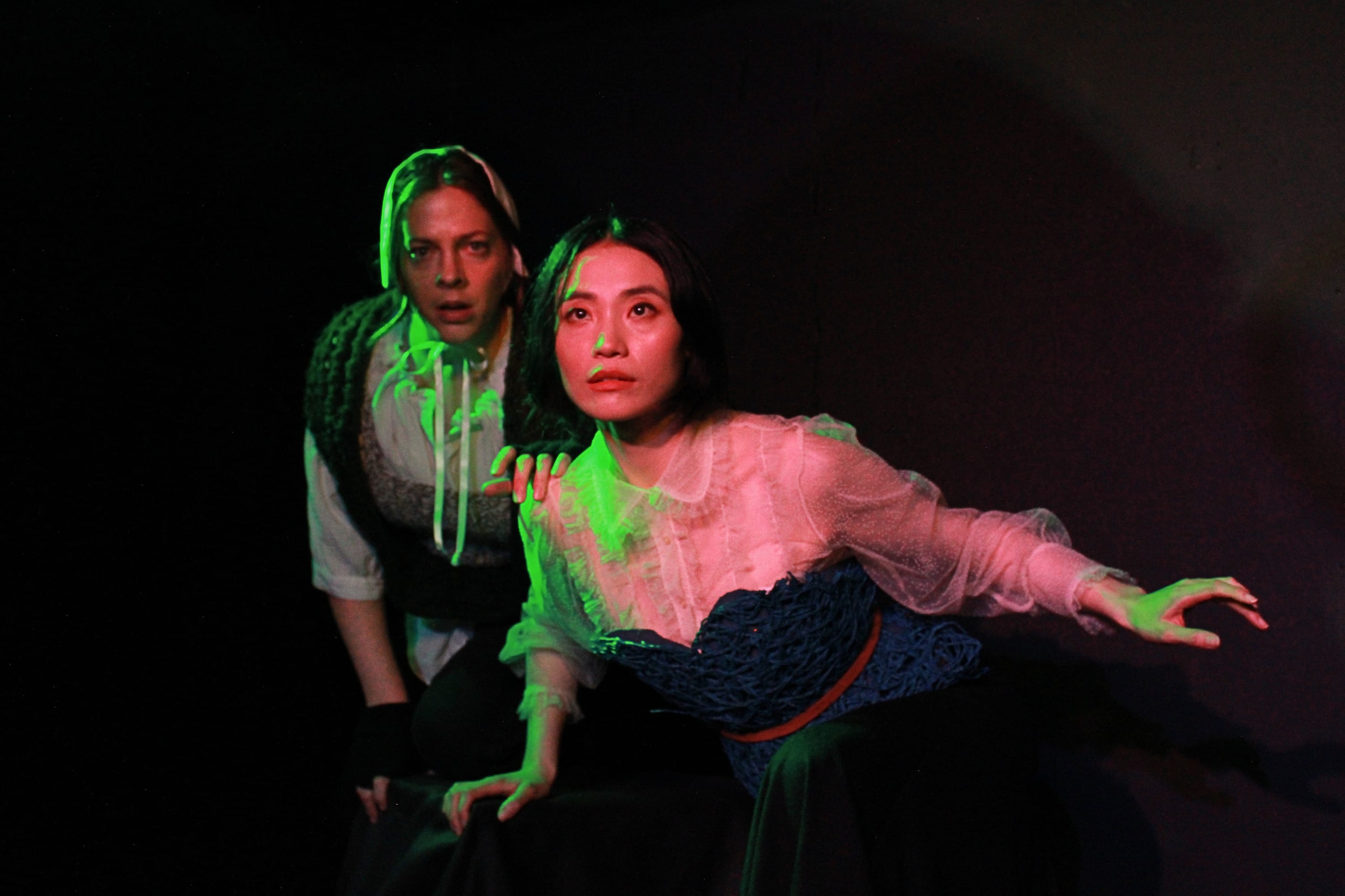 Two women looking into a green light