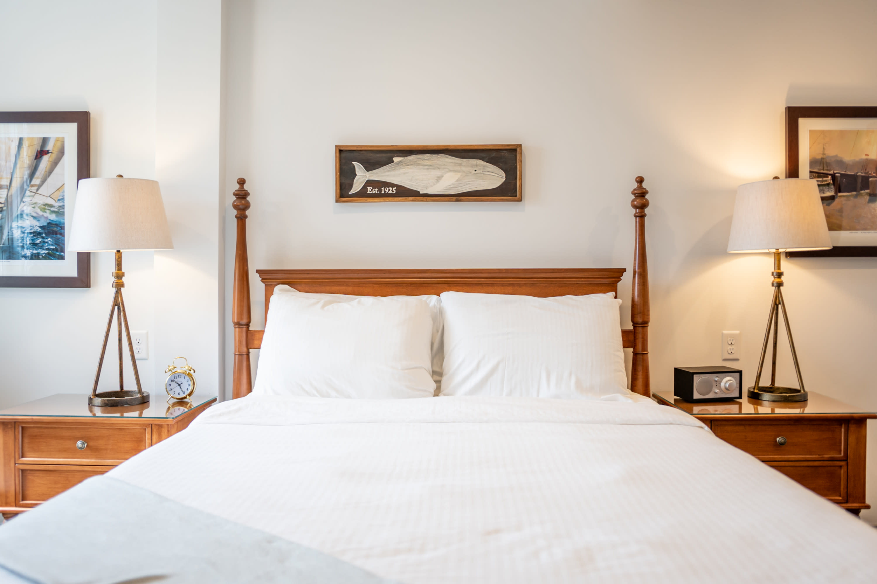 Hotel bed with fish art on wall in Downtown Mystic