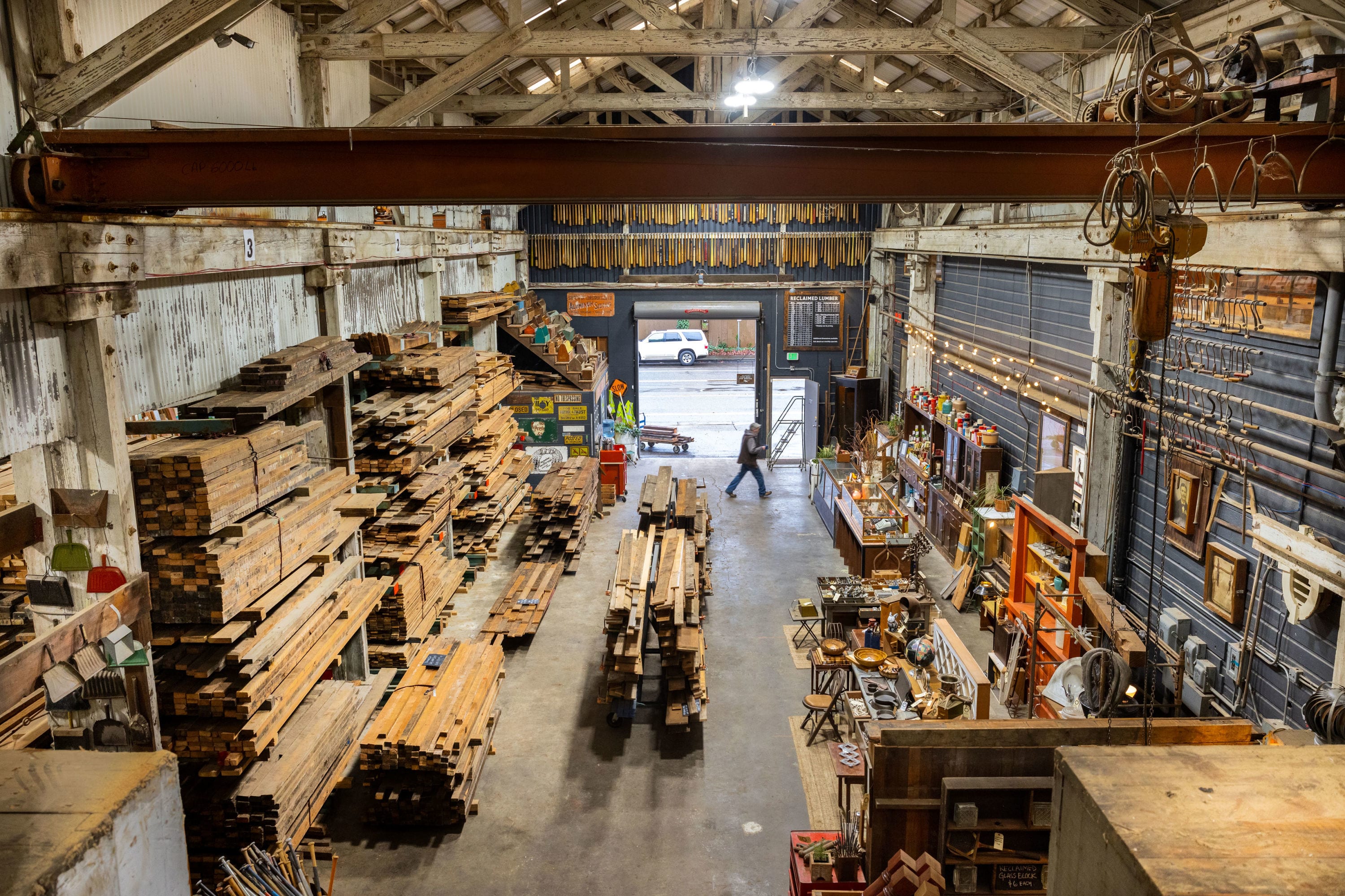 A photo taken from above of a reclaimed lumber warehouse with stacks of wood lining the walls