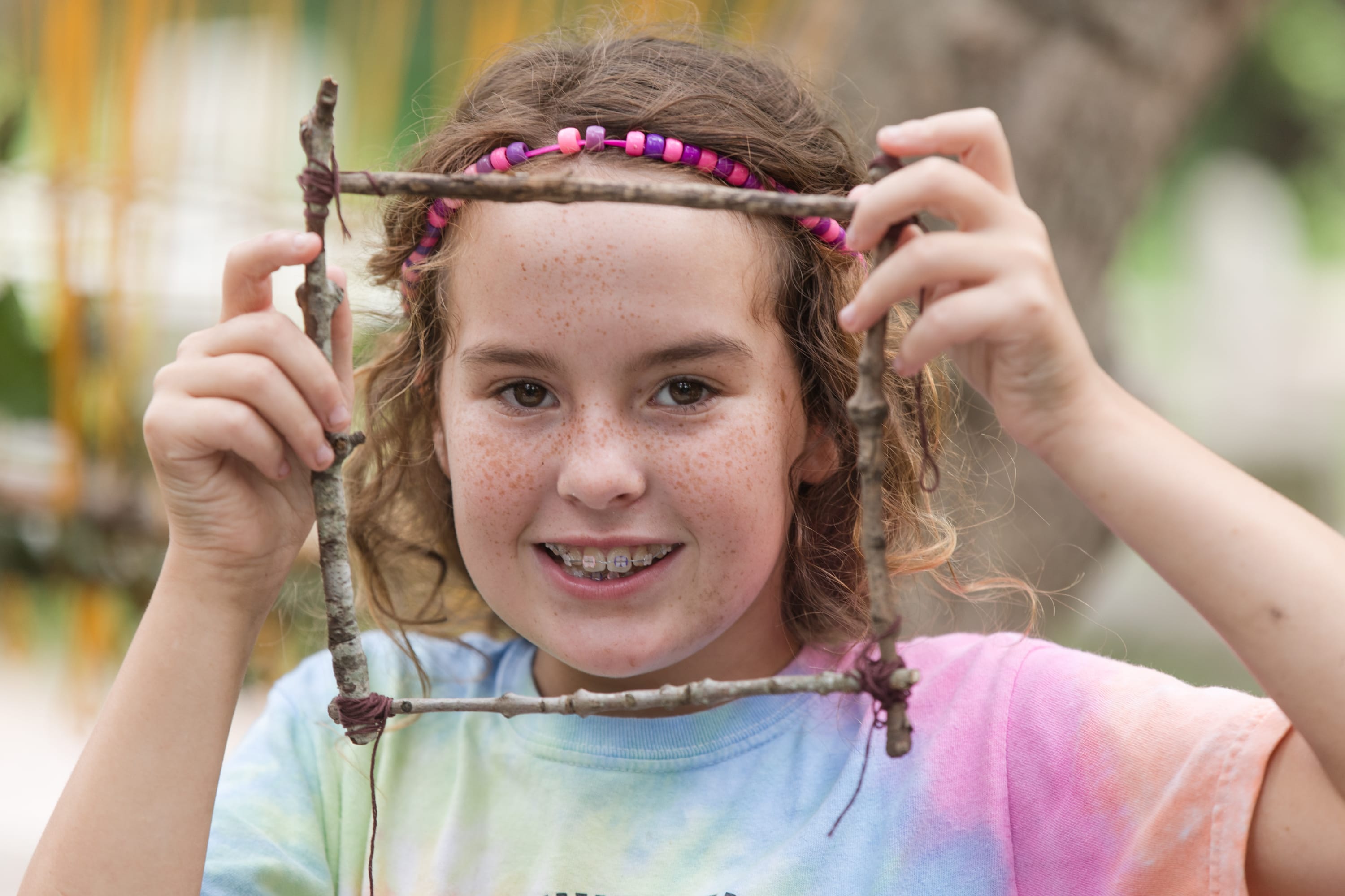 summer art camp at DPNC, girl smiling and showing her art project