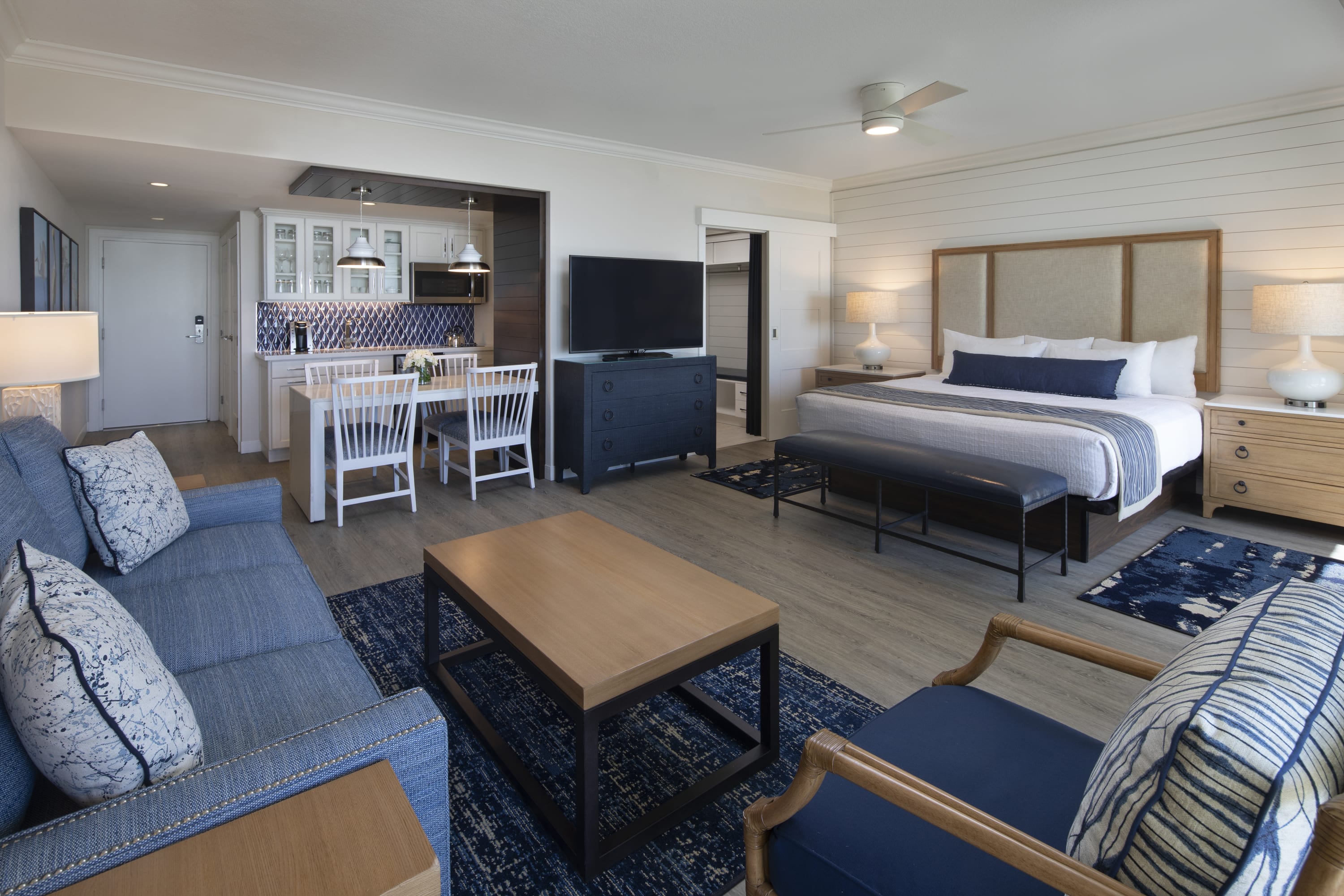 Junior suite with queen bed, living area with pull-out couch, chair, coffee table, Kitchen and dining table for four