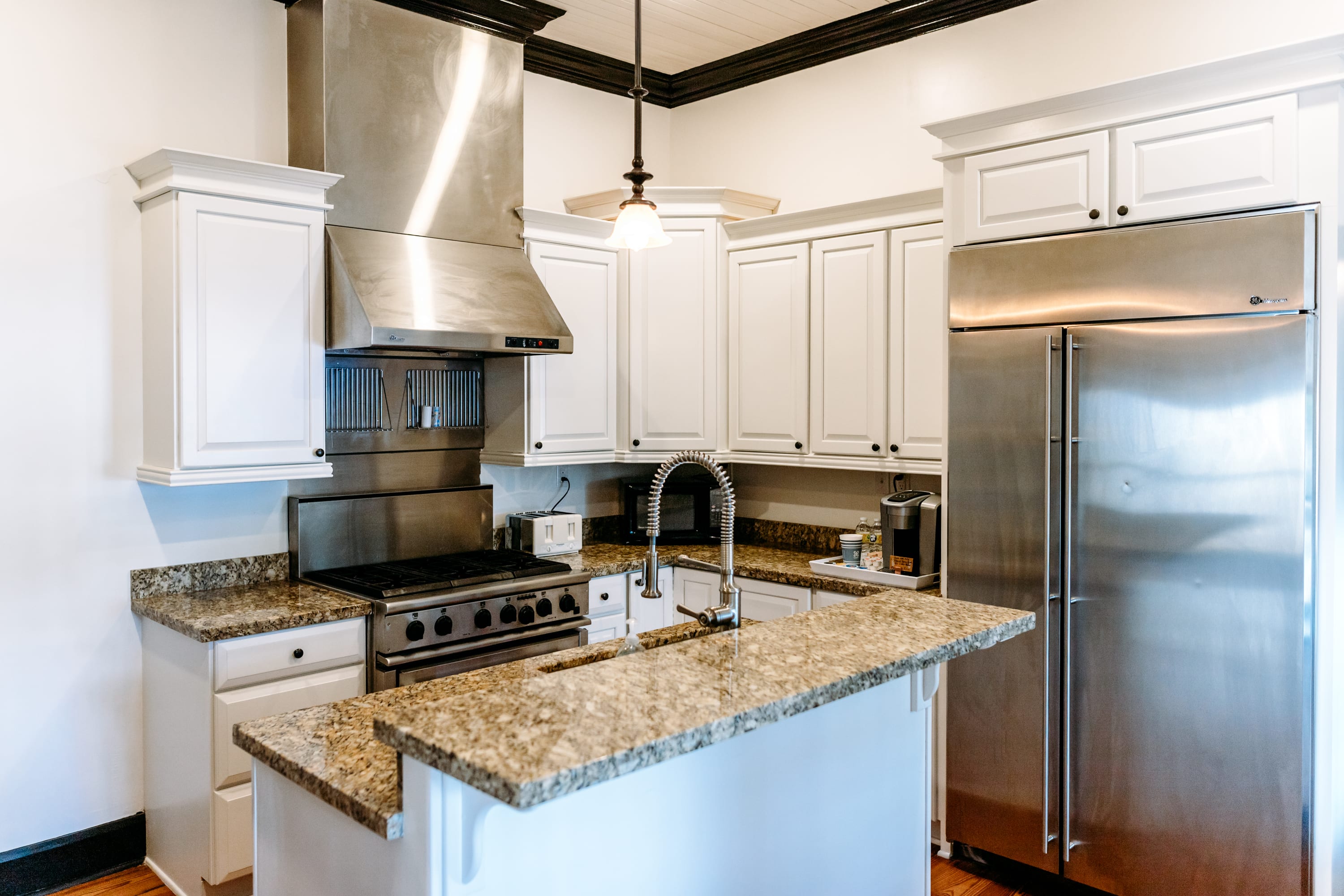 kitchen with island, six burner gas stove, full sized side-by-side refrigerator