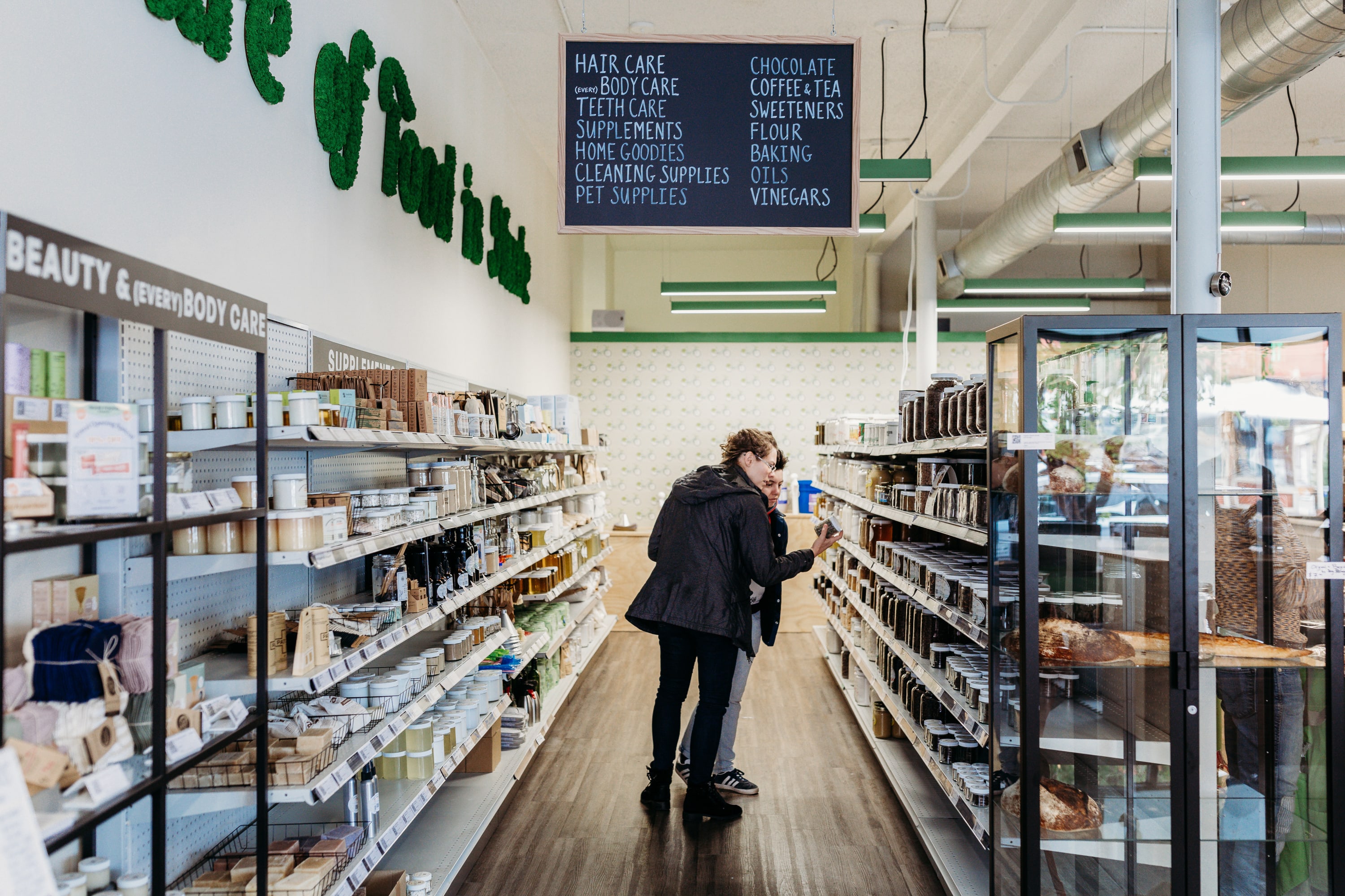 shoppers look at shelves of jarred goods at a zero waste store