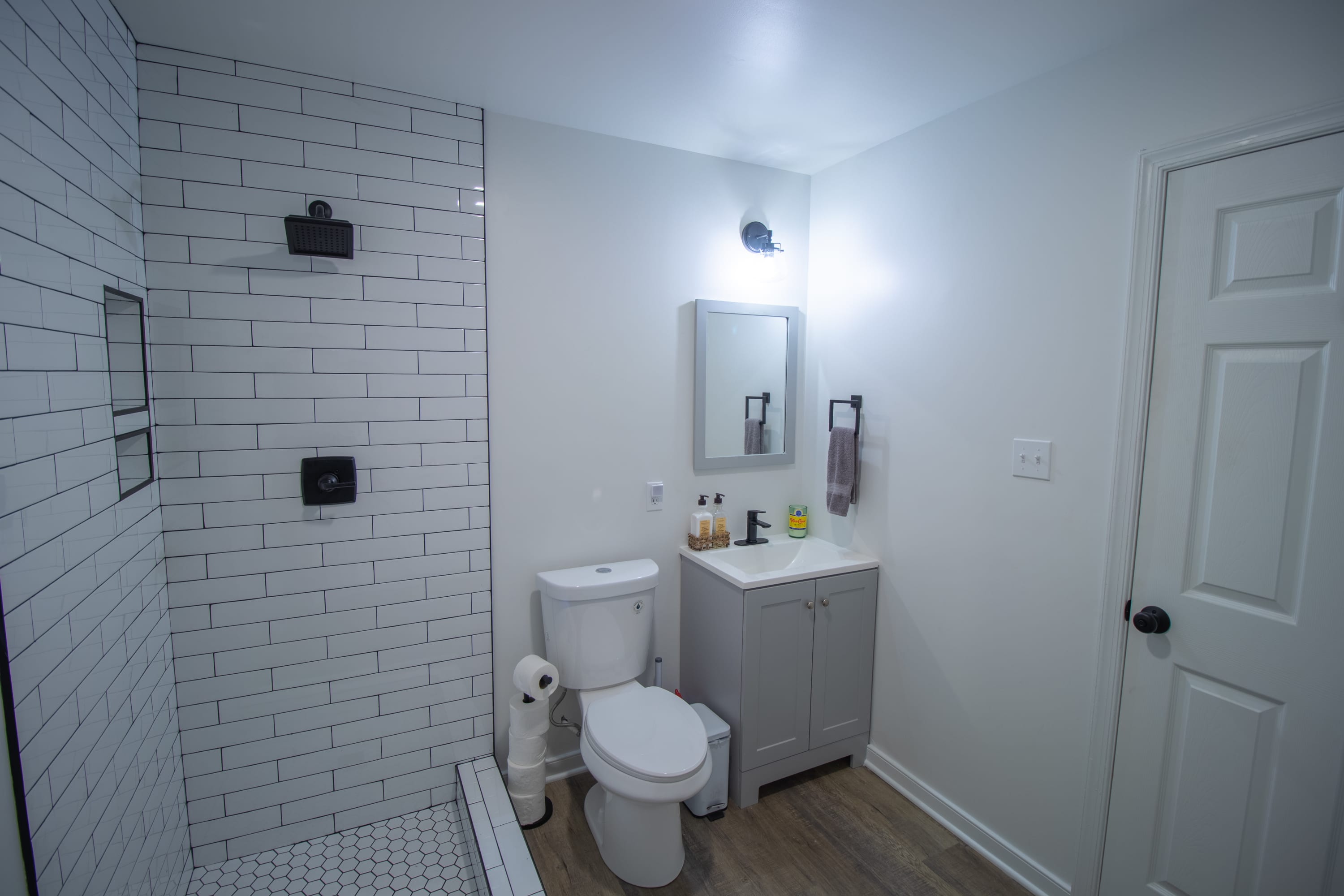 Basement bathroom with shower, toilet, and modern vanity.