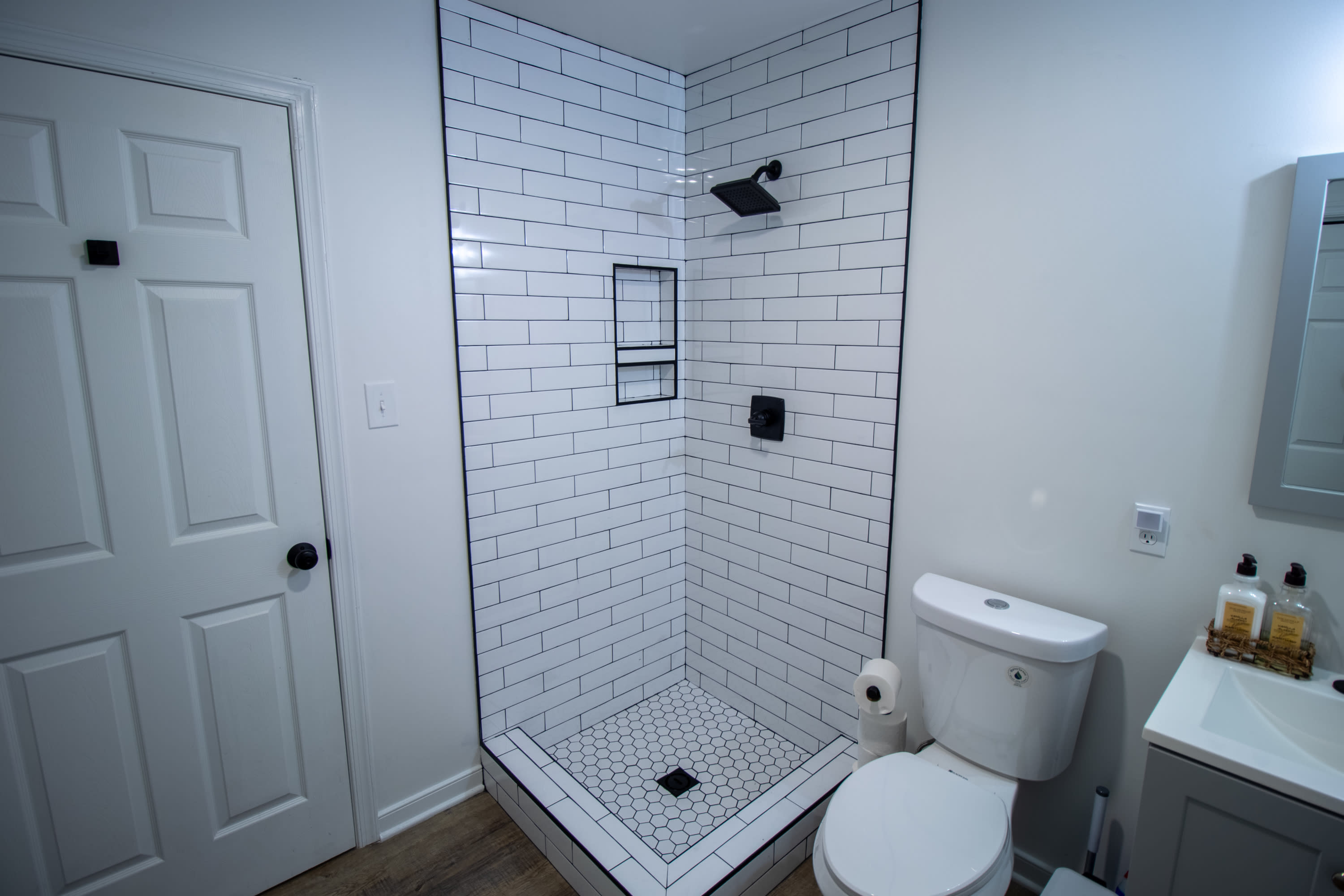 Custom tiled basement shower with built-in niche.