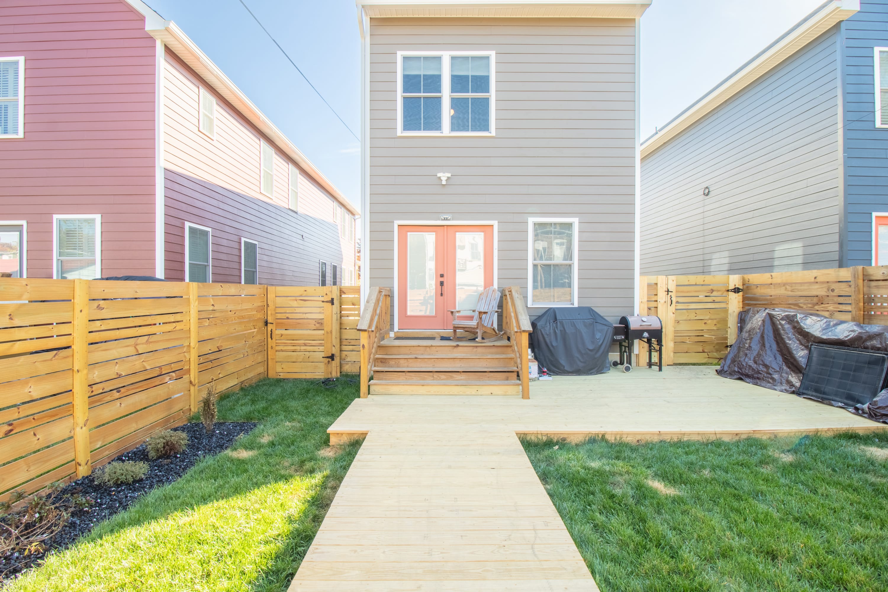 New wood deck and walkway in fenced backyard.