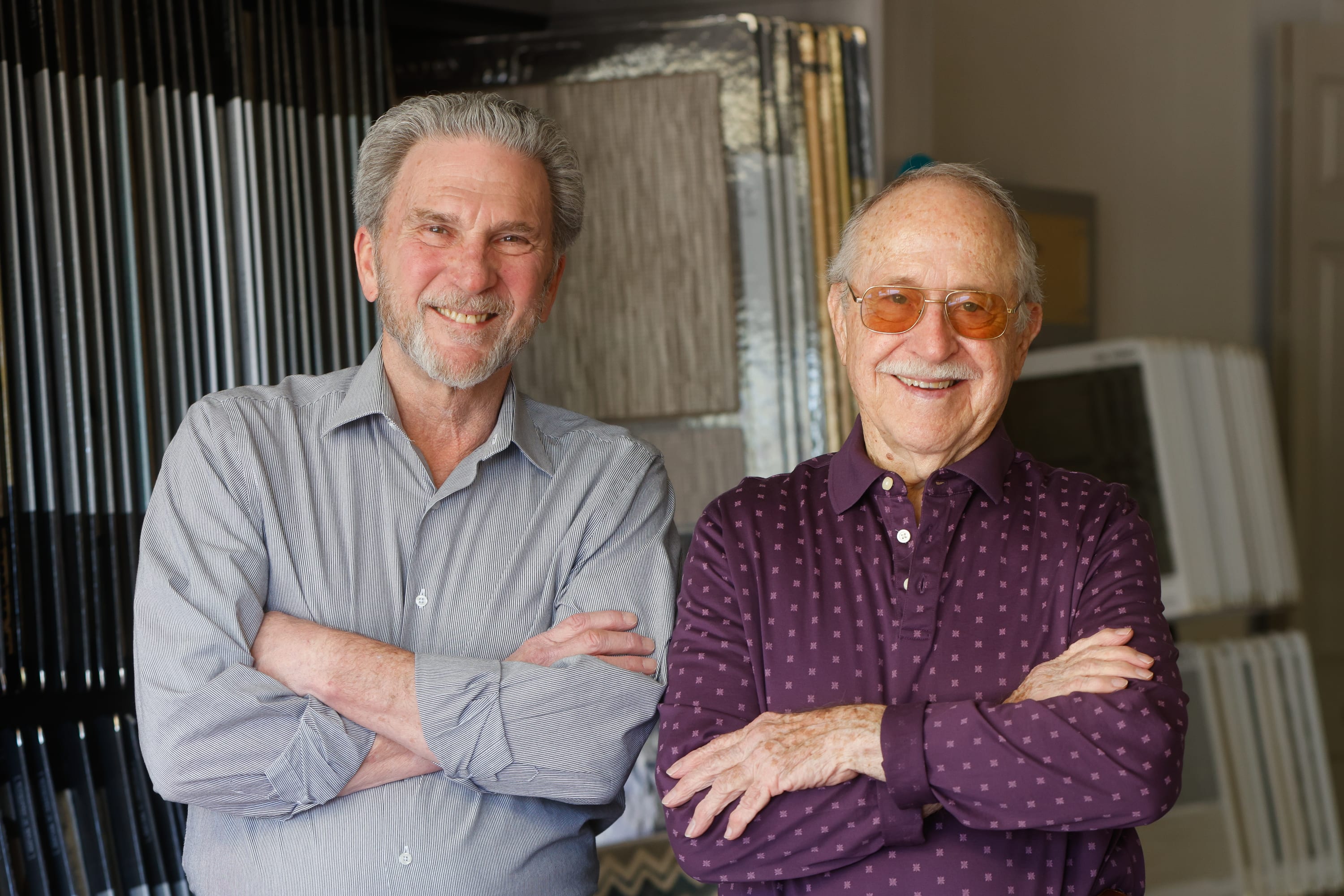 two smiling people standing in front of two carpet displays