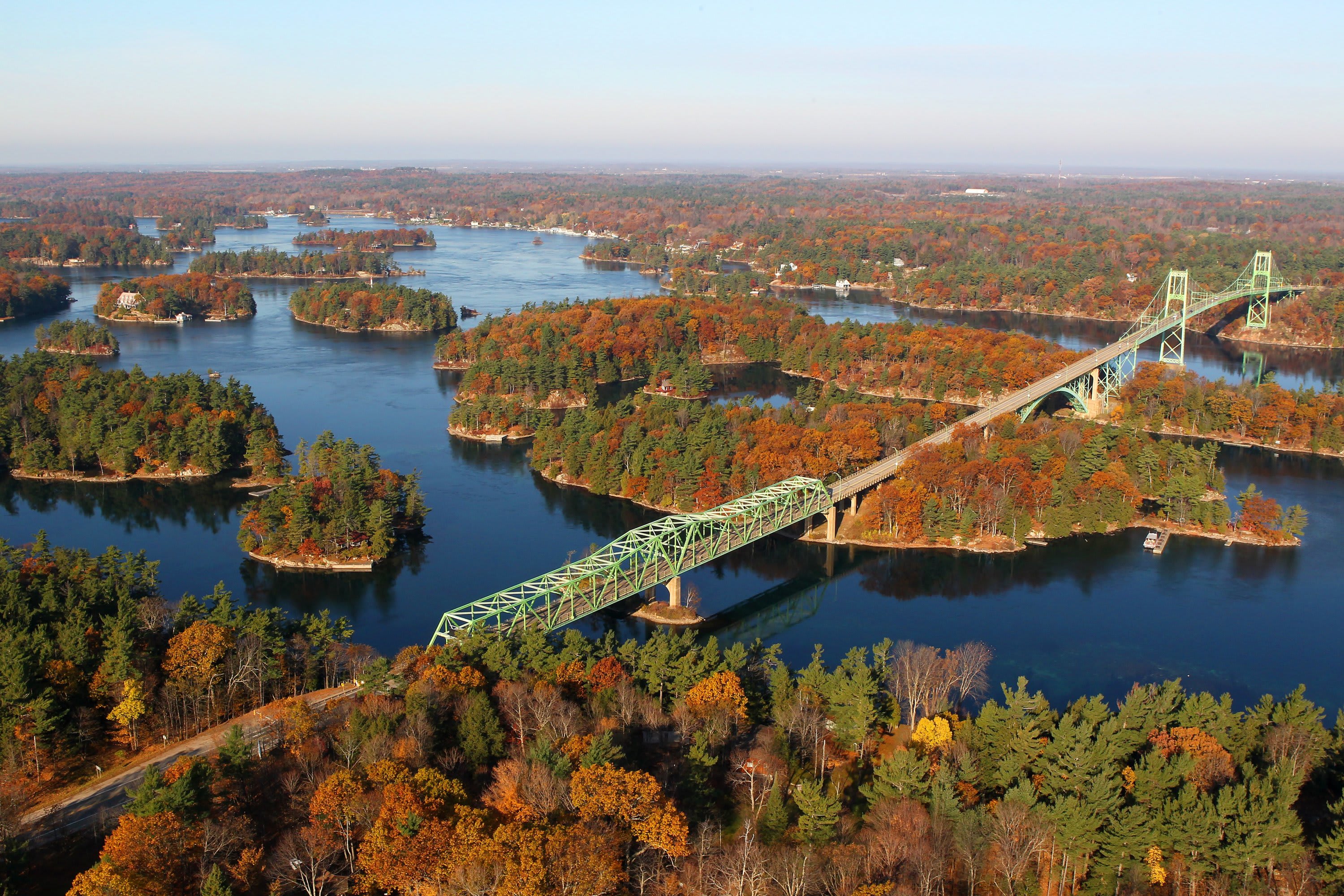 1000 Islands Bridge in the fall, ariel view of the mint green bridge among the islands with fall foliage