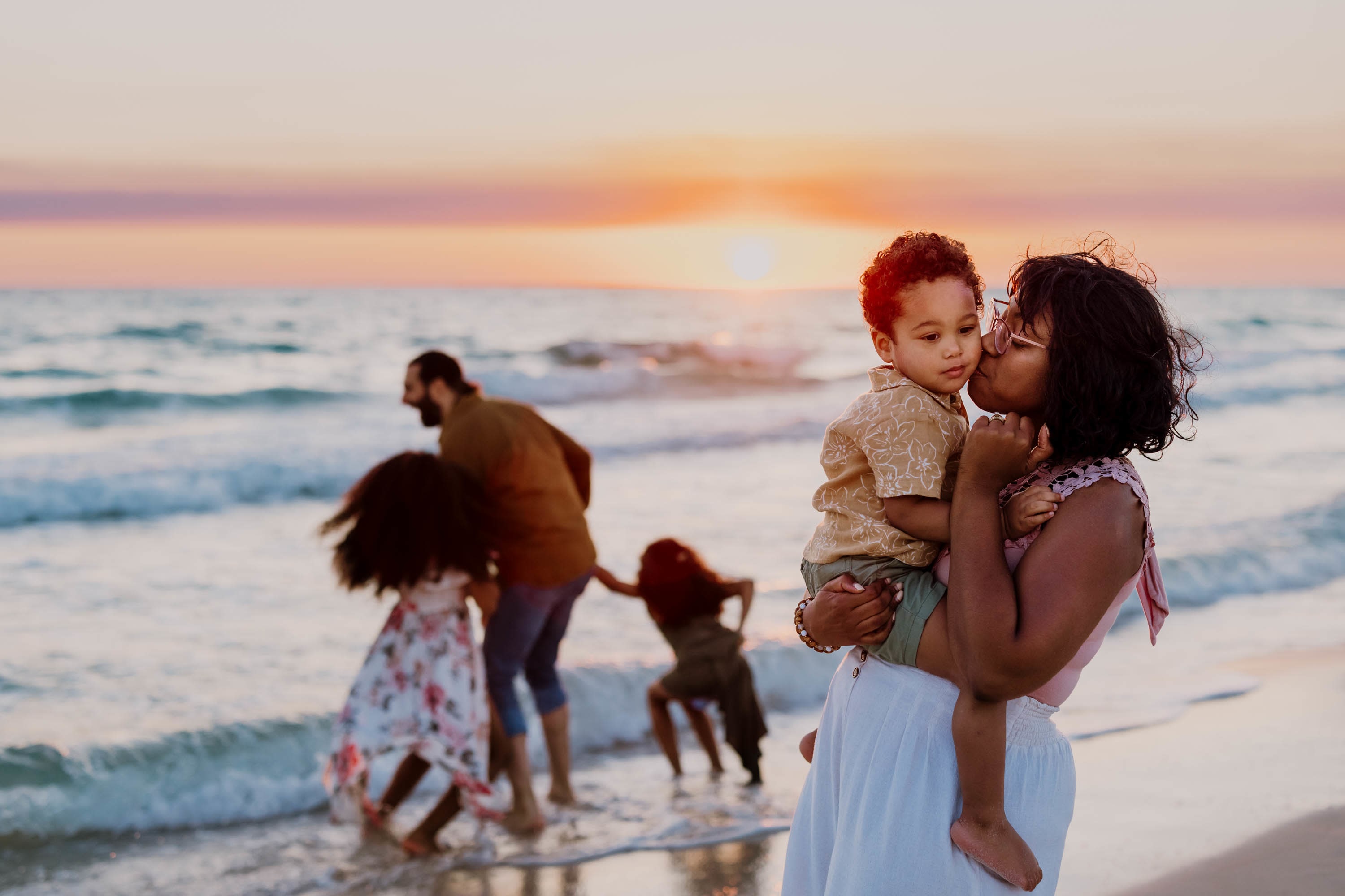 family playing in the waves