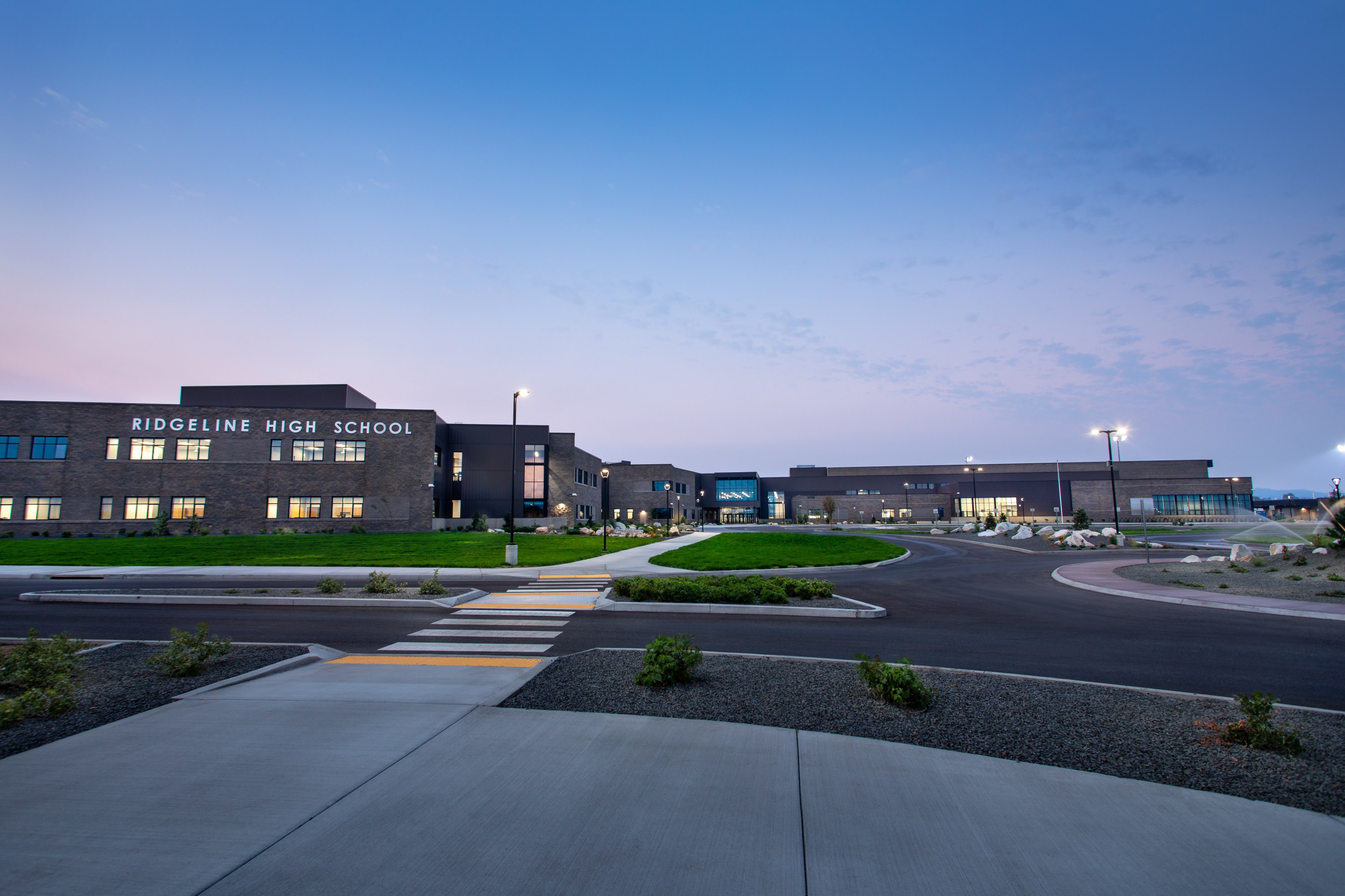 ground level photo looking at the large high school from street view at dusk