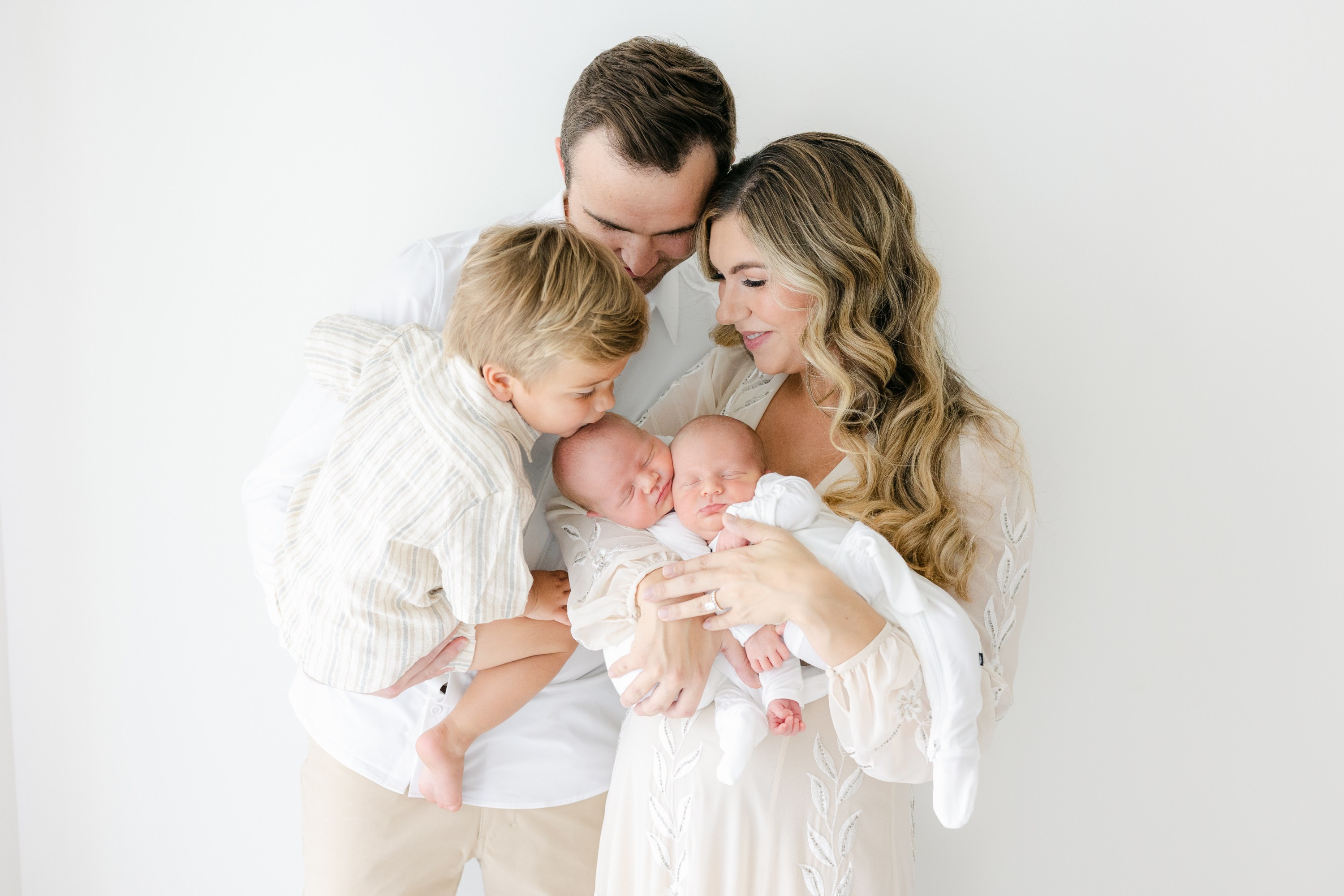 Indianapolis family at their newborn photo shoot dressed in all white in a natural light studio at Lindsay Konopa Photography