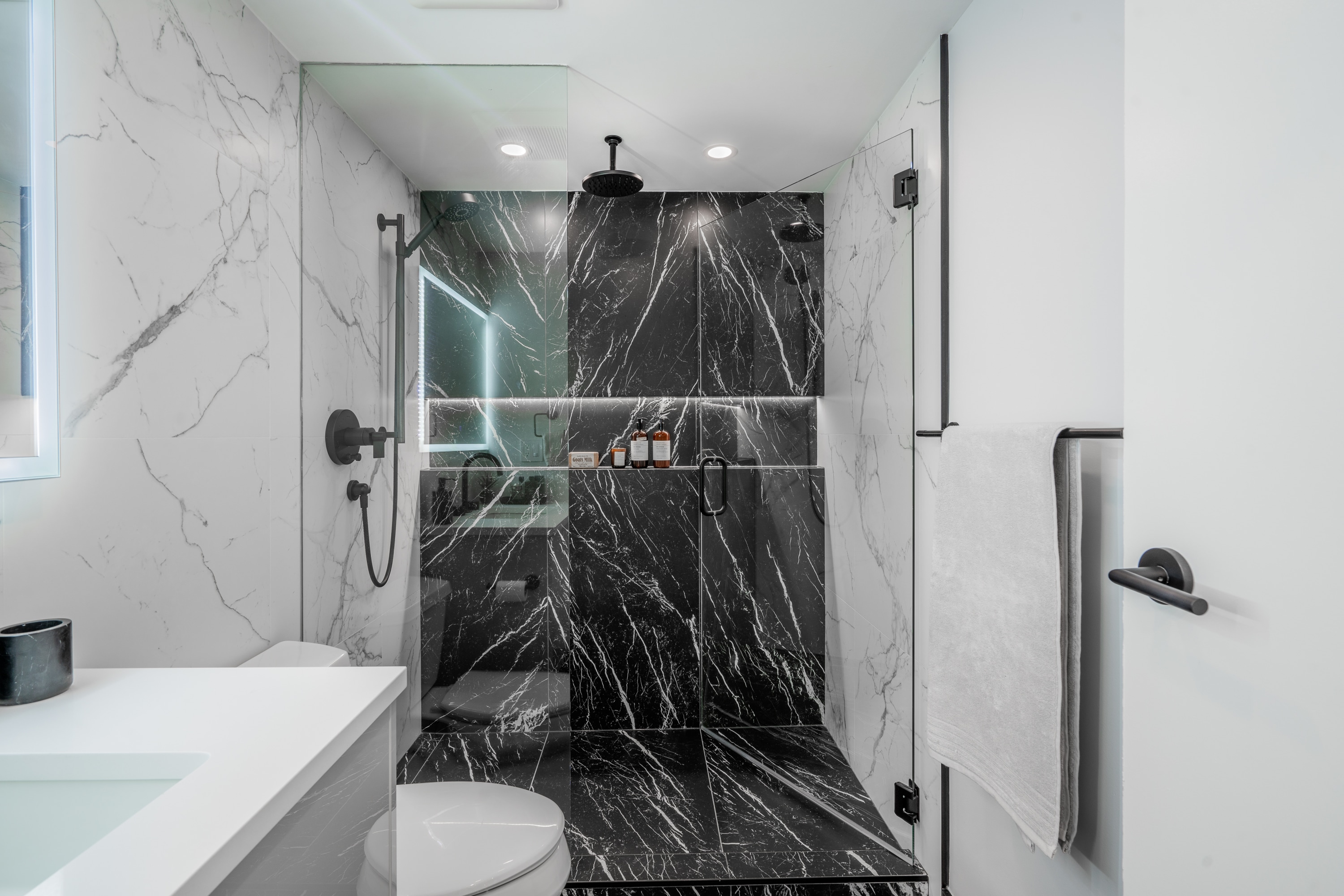 bathroom-renovation-in-vancouver-black-and-white-marble-wall-tiles-black-plumbing-fixtures-sleek-niche