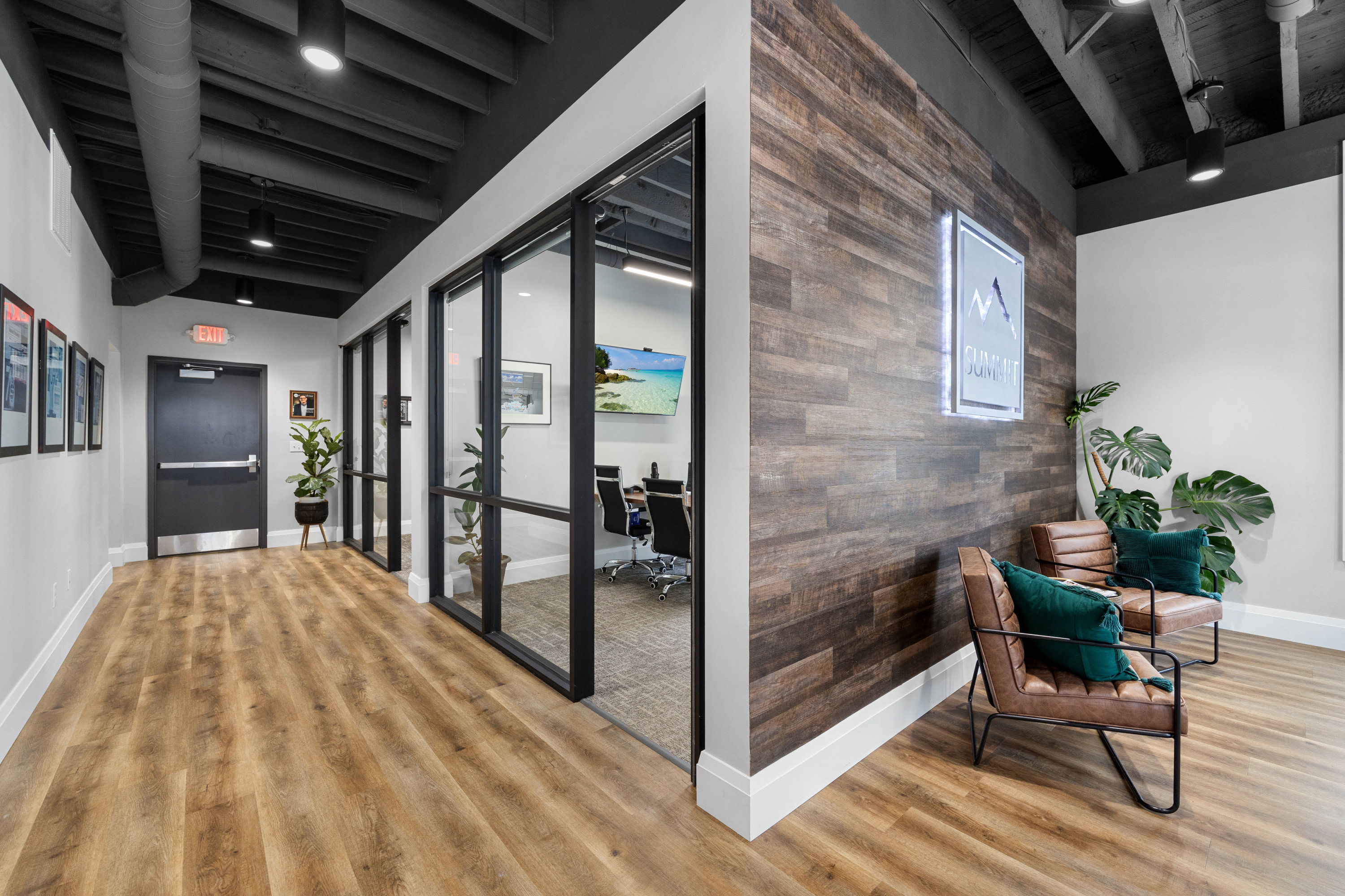 Interior view of Summit, featuring a hallway with wooden floors, framed pictures on the wall, a gl