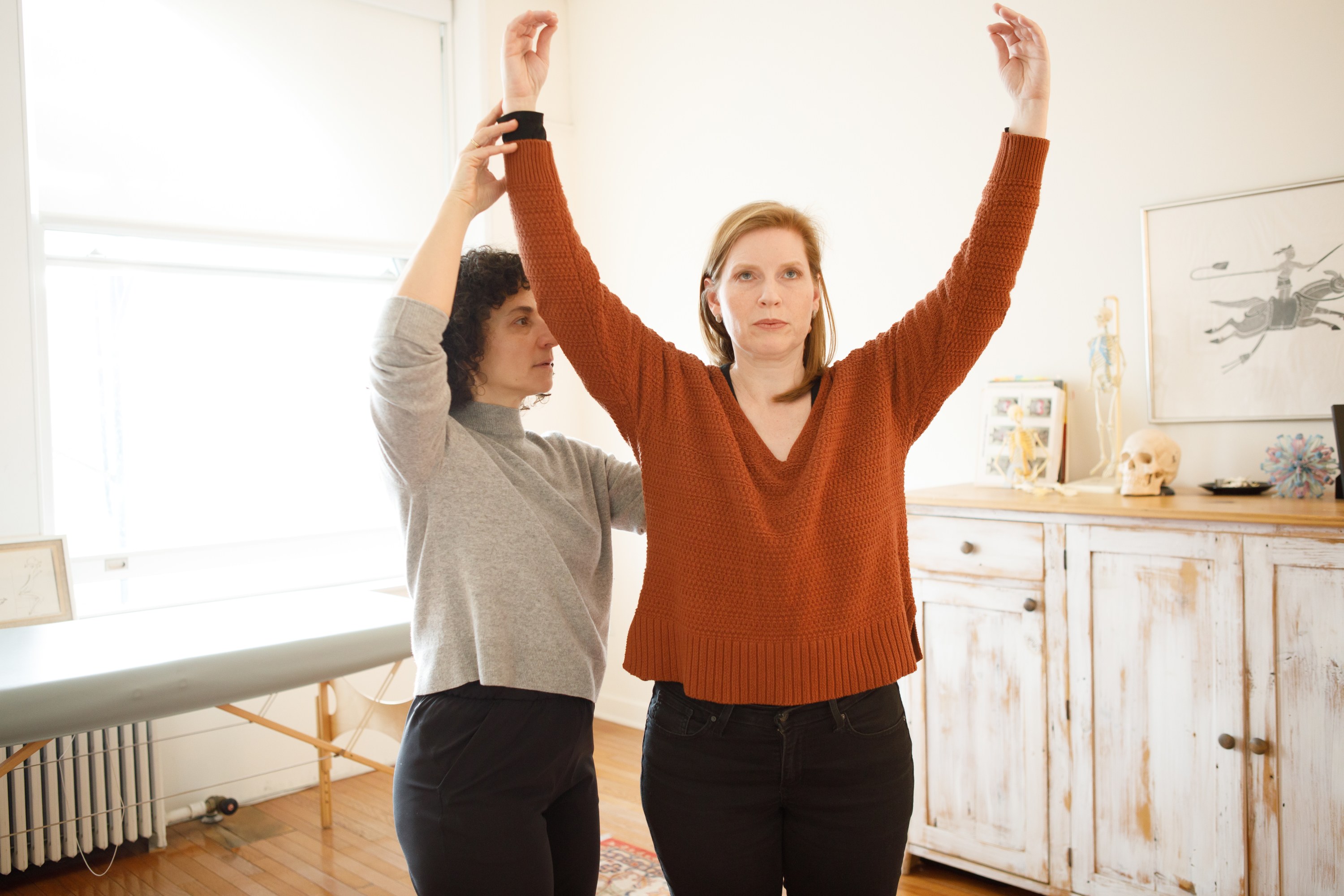 photo of Rachel working hands-on with Eleanor Taylor, whose arms are raised above her head