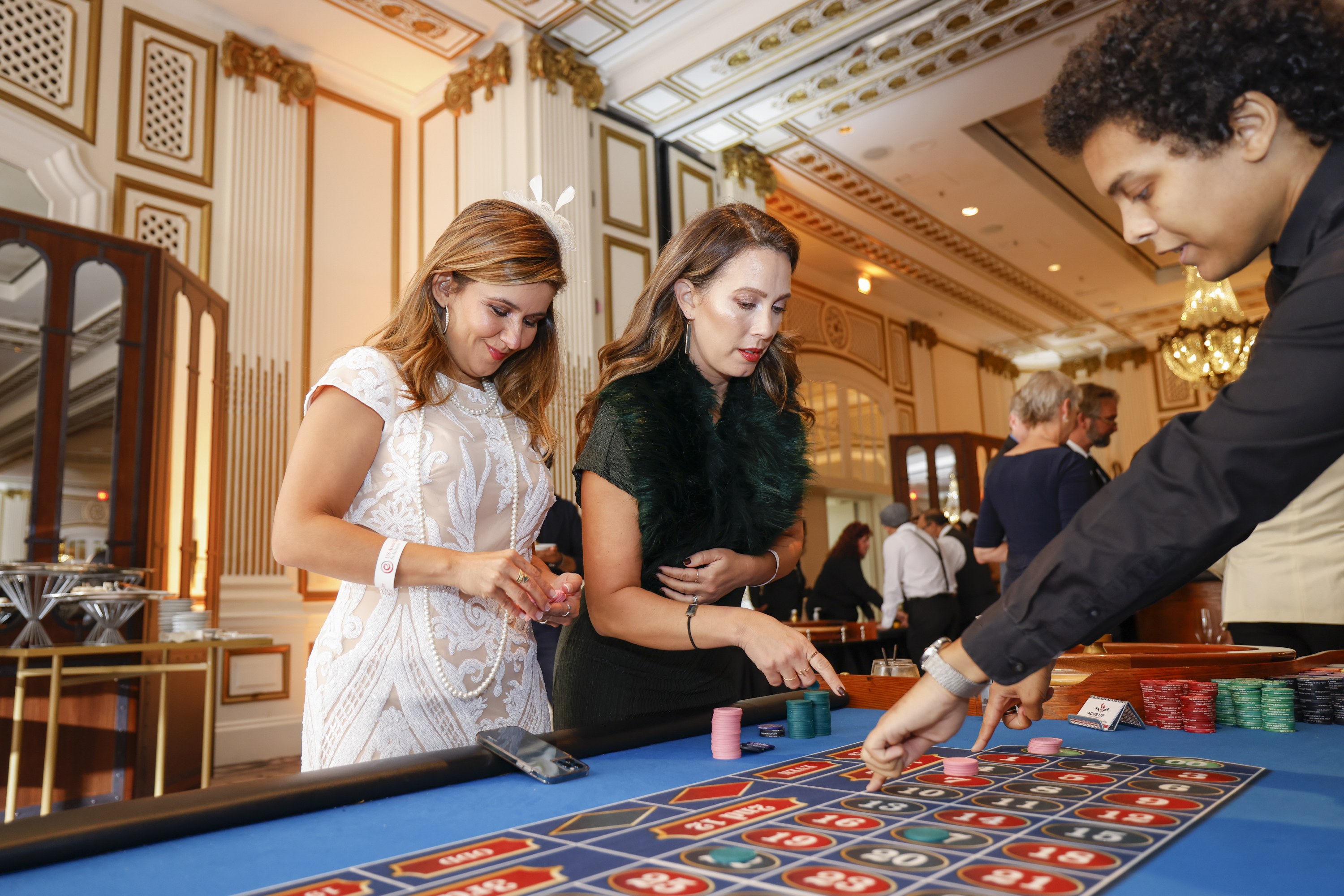 Roulette dealer teaching players how to play