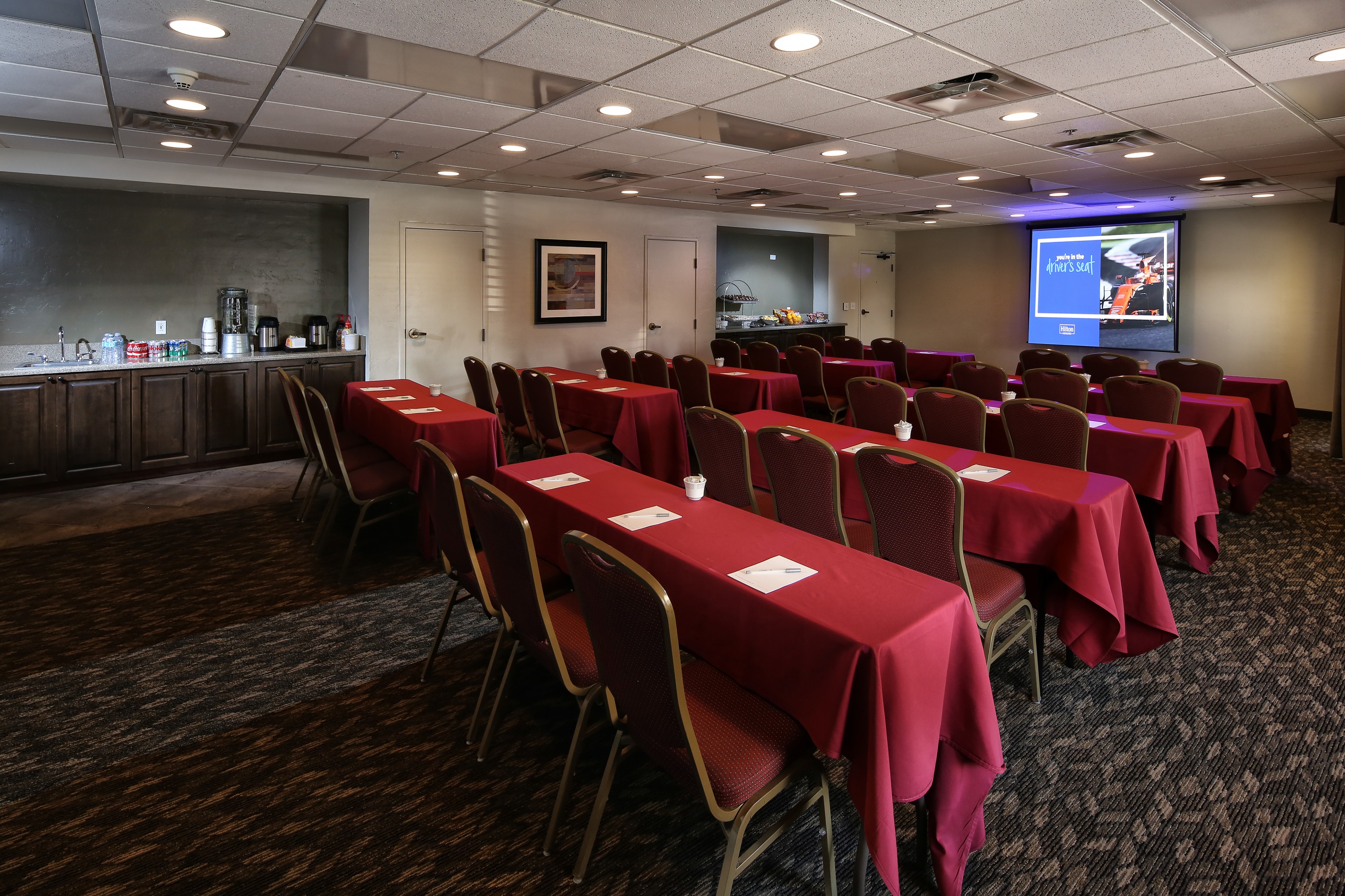 Meeting room at Hampton Inn & Suites Tucson Mall with tables and chairs.