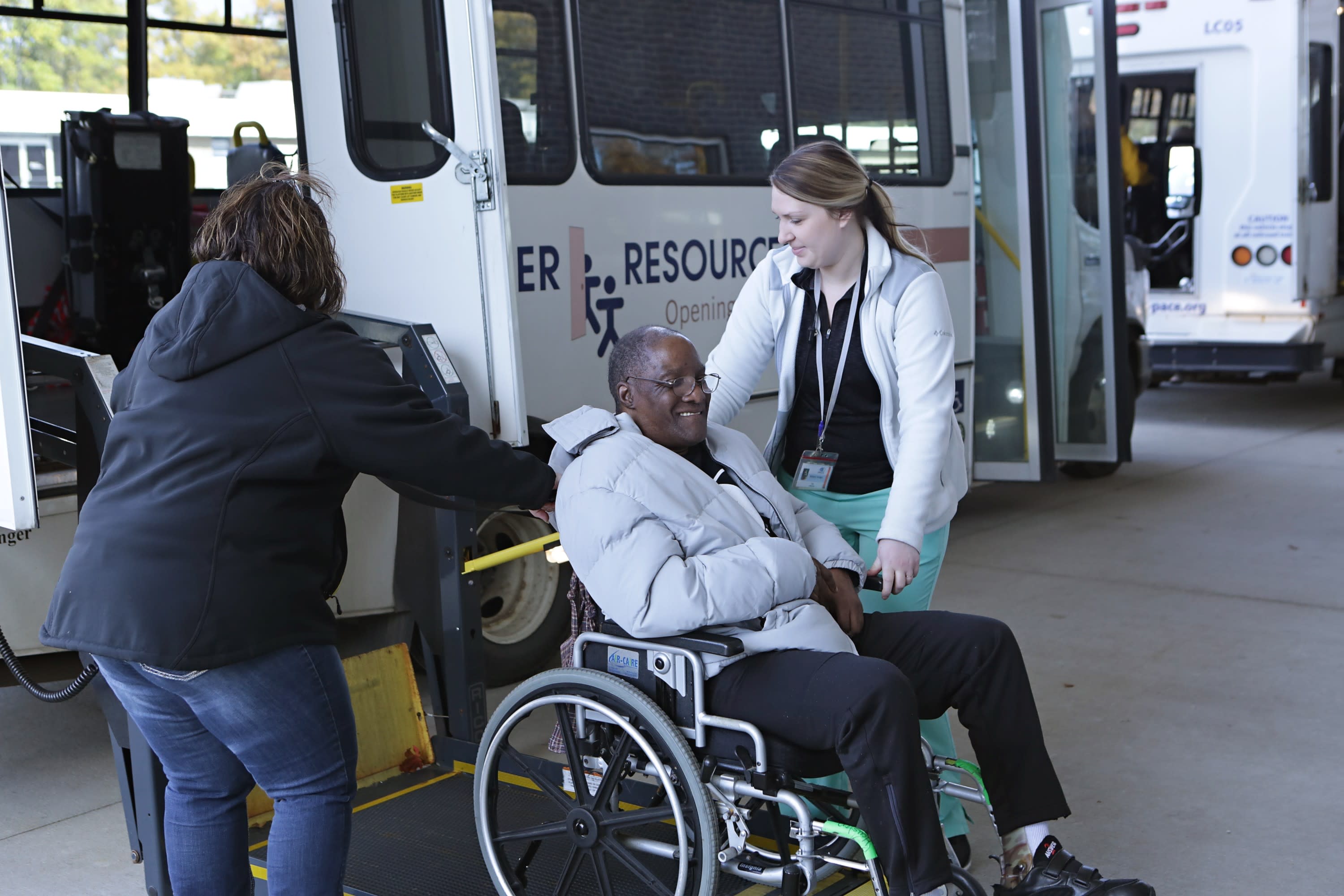 A senior gentleman who is in a wheelchair gets assistance to ride a LifeCircles PACE bus.