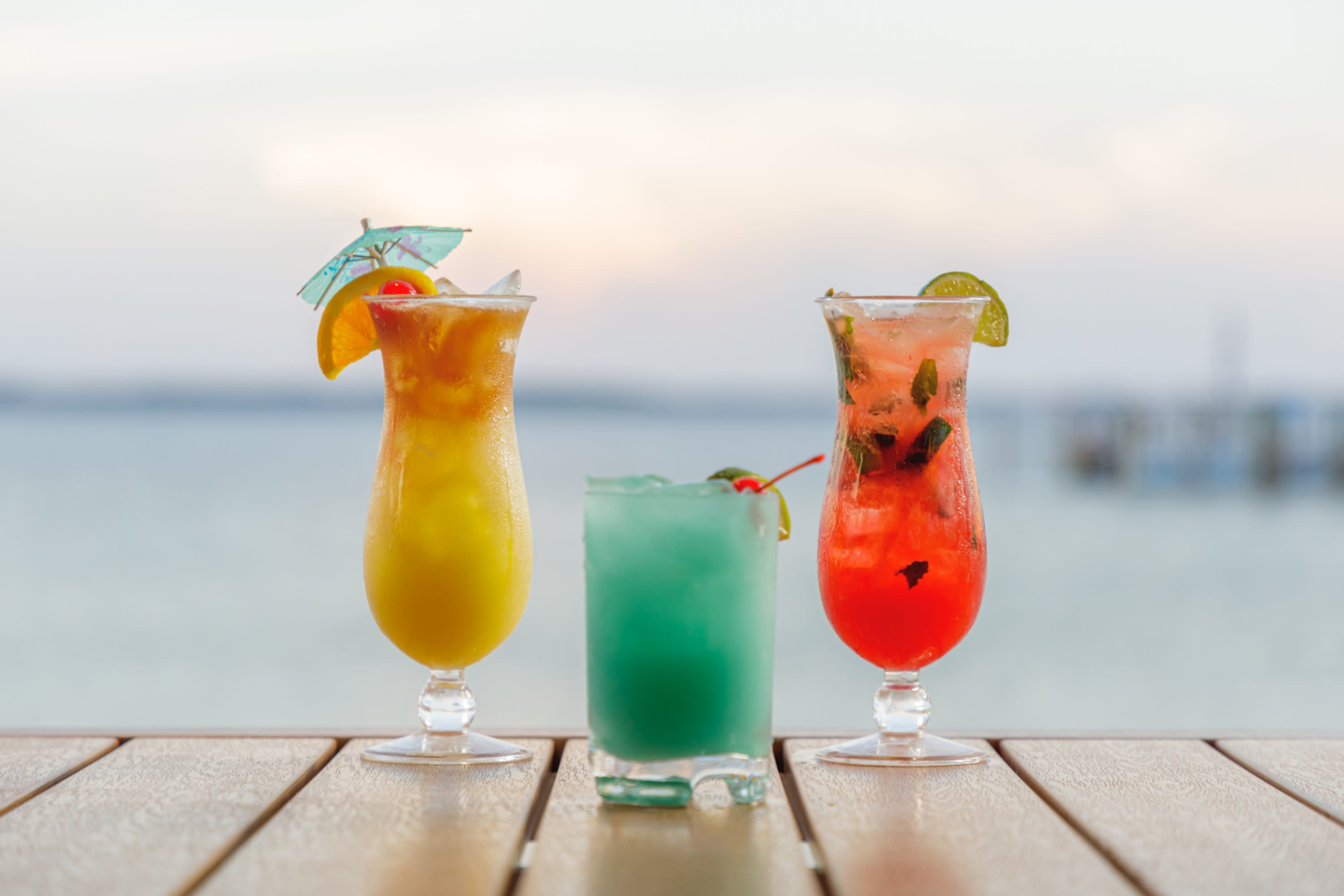 three cocktails sitting on table