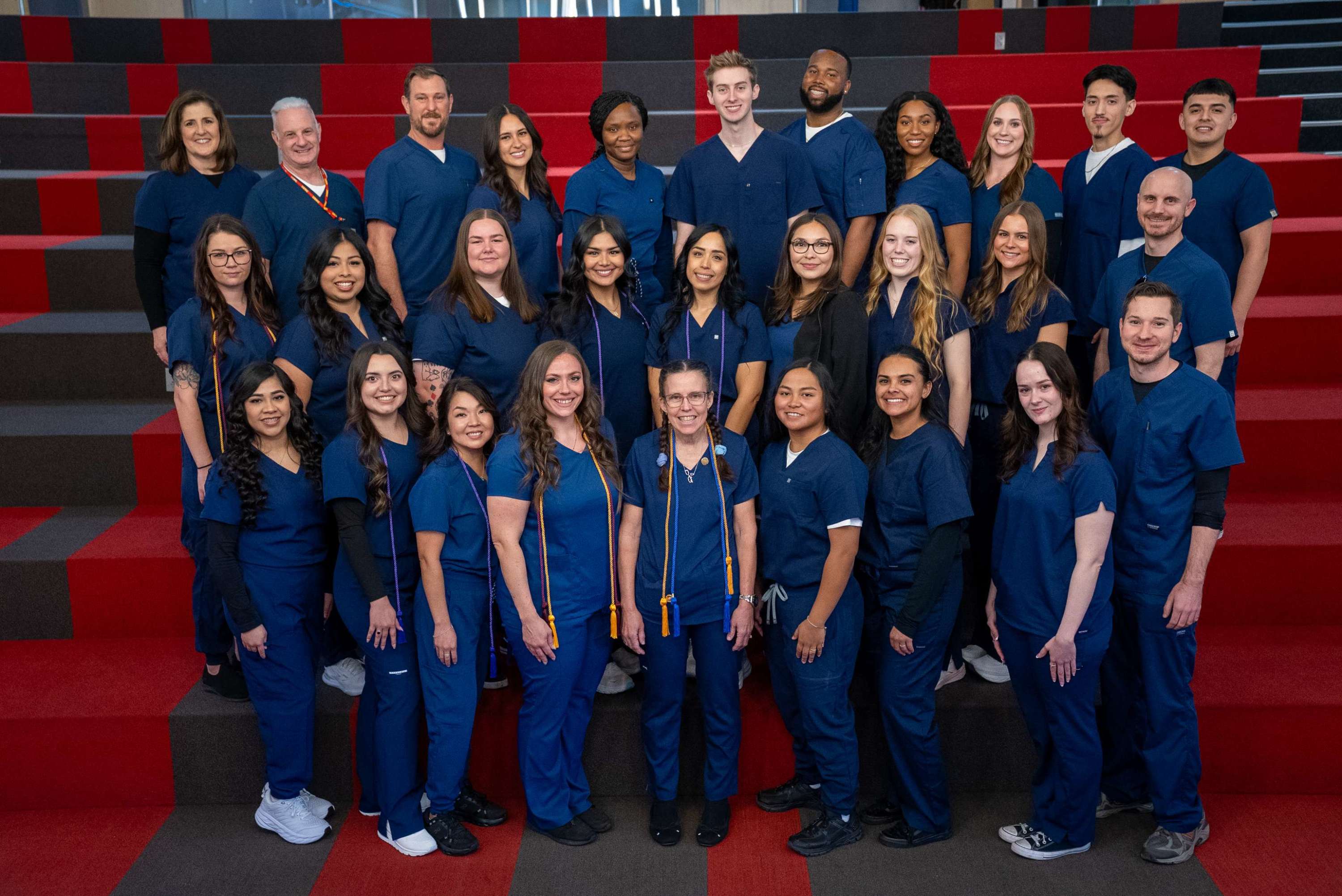 One of two groups of MCC RN graduates in navy blue scrubs.