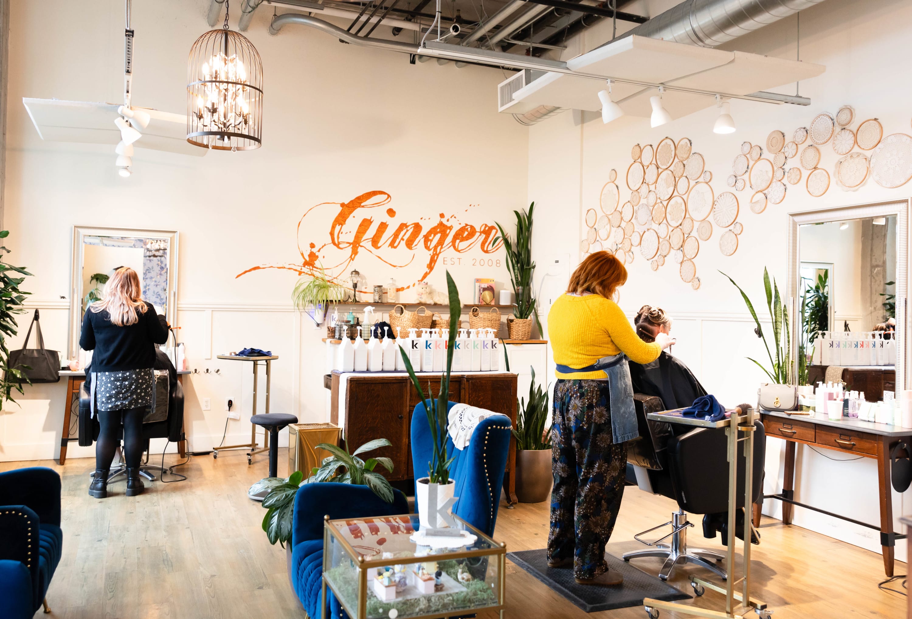 The inside of a Ginger & Maude Hair Salon with two hairstylists doing the hair of clients