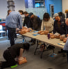 A group of student performing CPR compressions on manikins