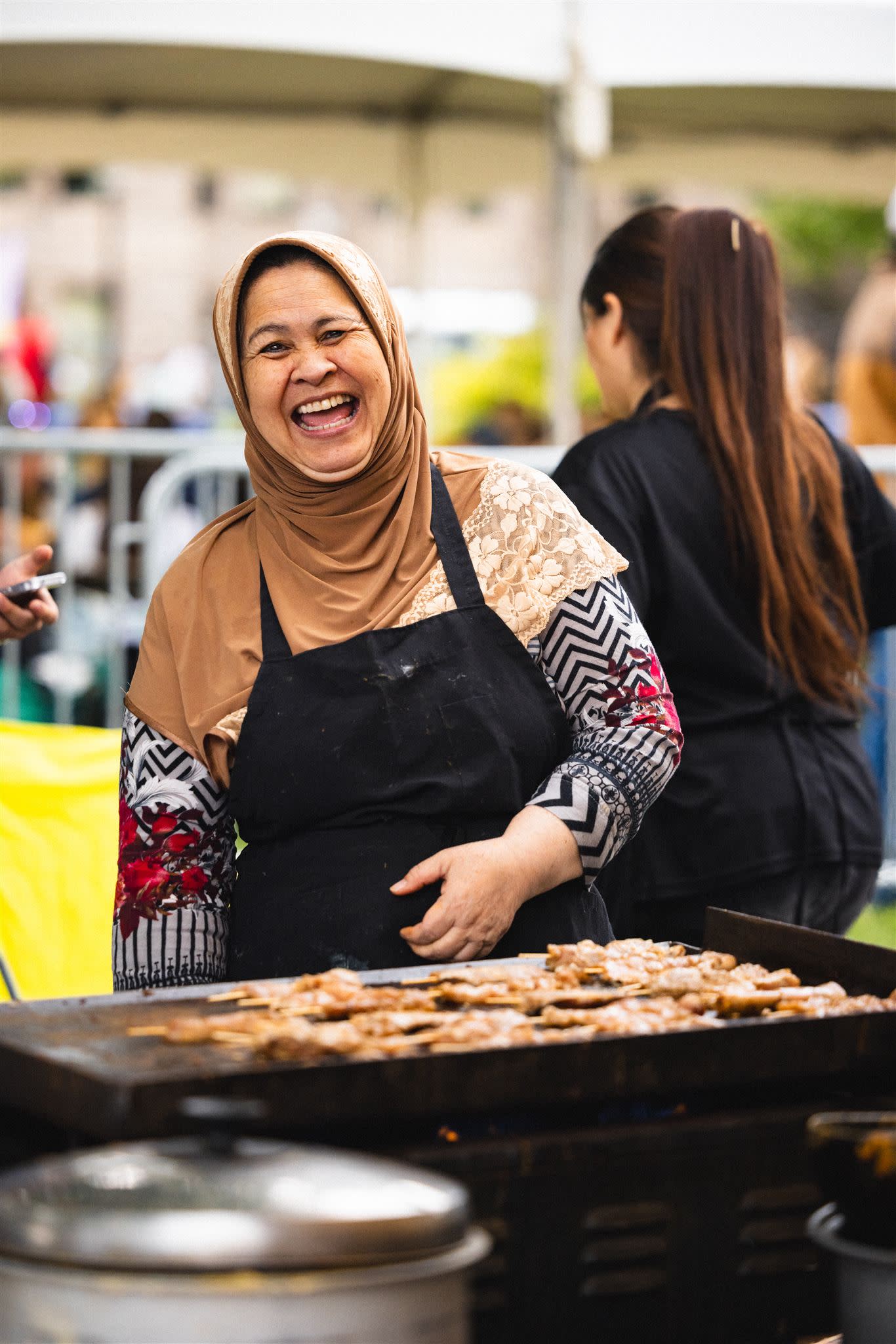 Woman cooking and smiling at festival