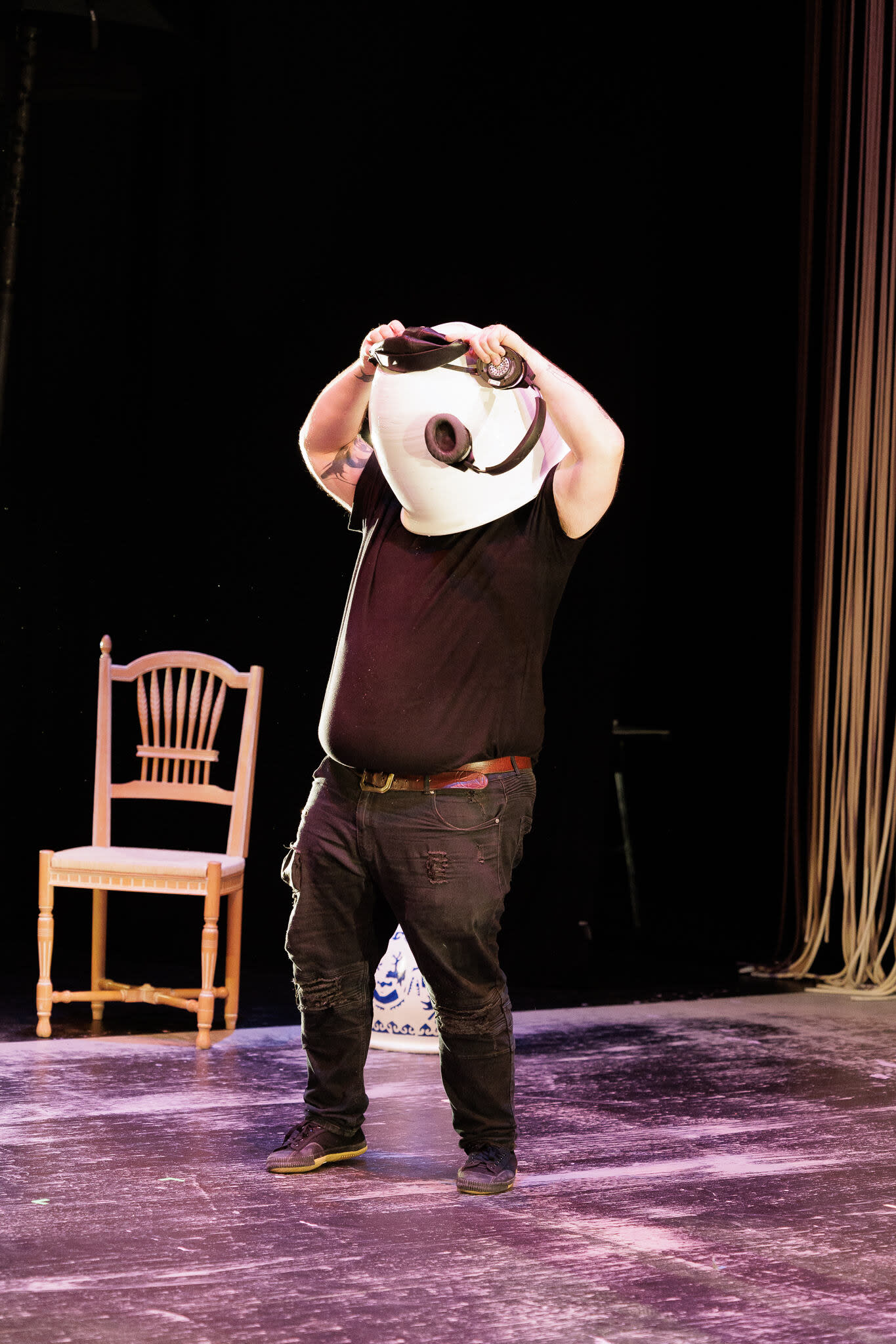 a man in all black with a white shape taking over his head