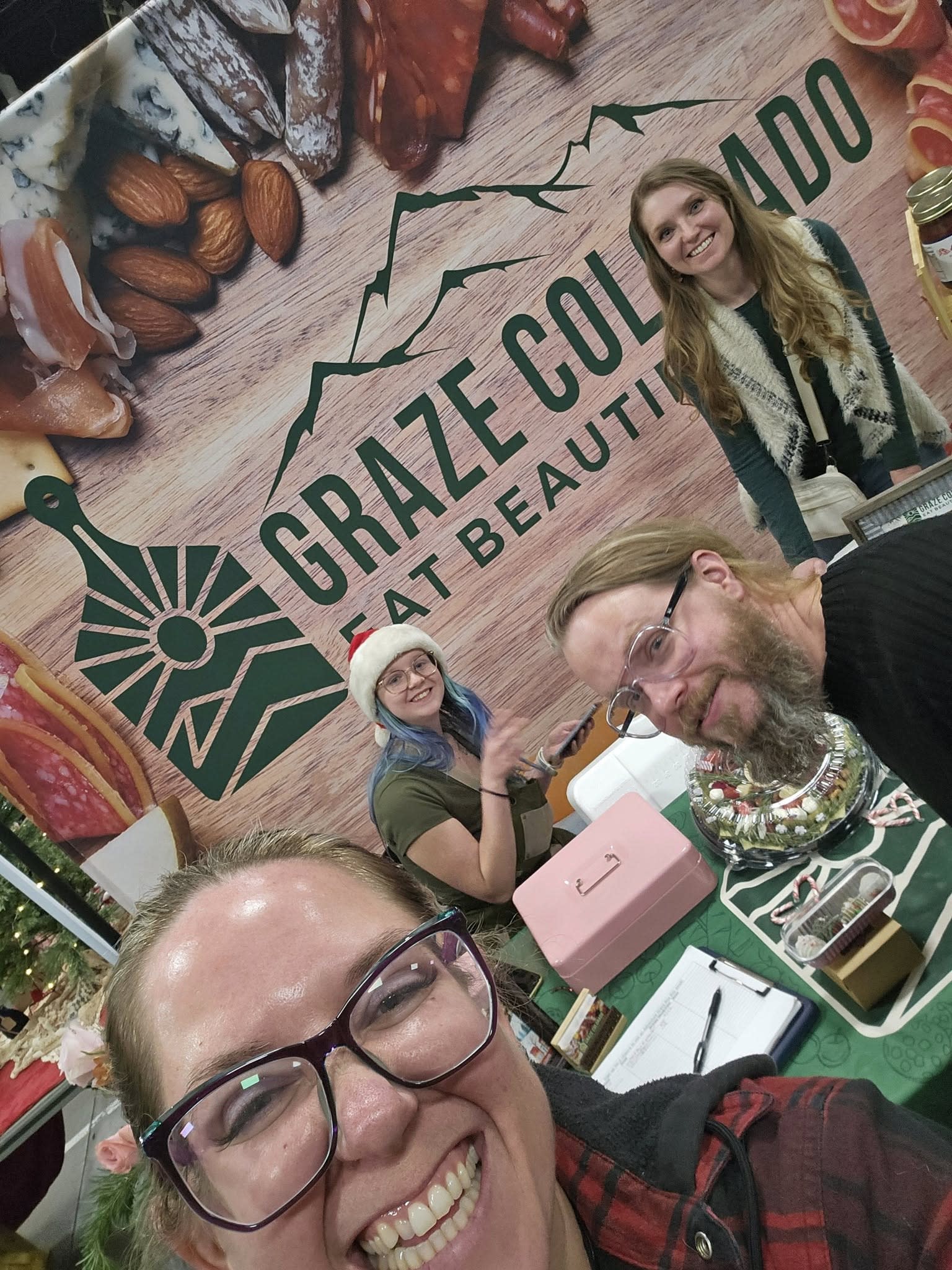 Four people taking a selfie at at a table.