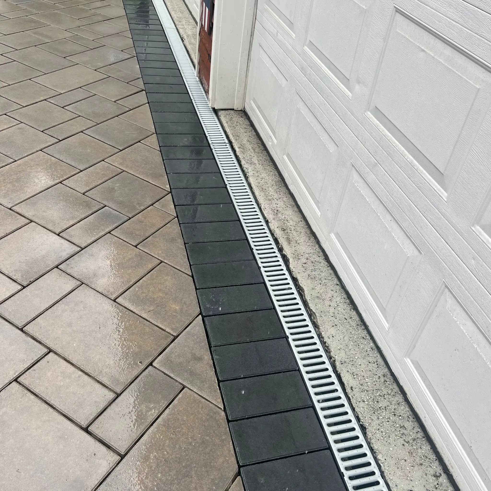 Driveway drainage installation with a channel drain to stop water pooling and improve runoff in Wellesley, MA.