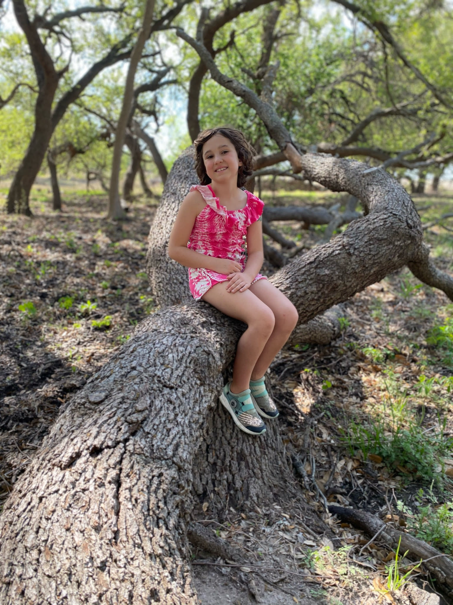 girl sitting on tree trunk