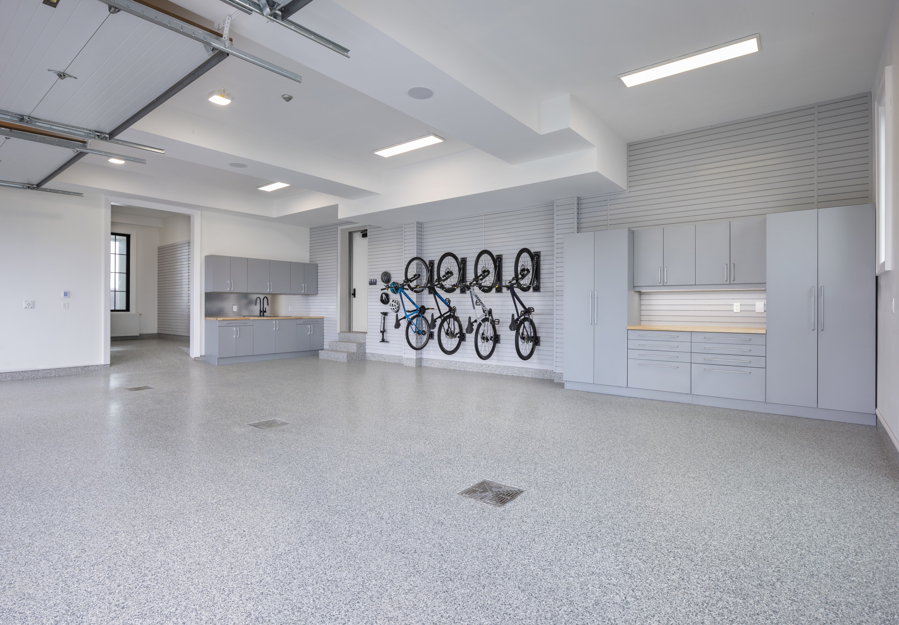 6-car garage with polyaspartic floor coating, custom cabinets, vertical bike racks, and slatwall panels