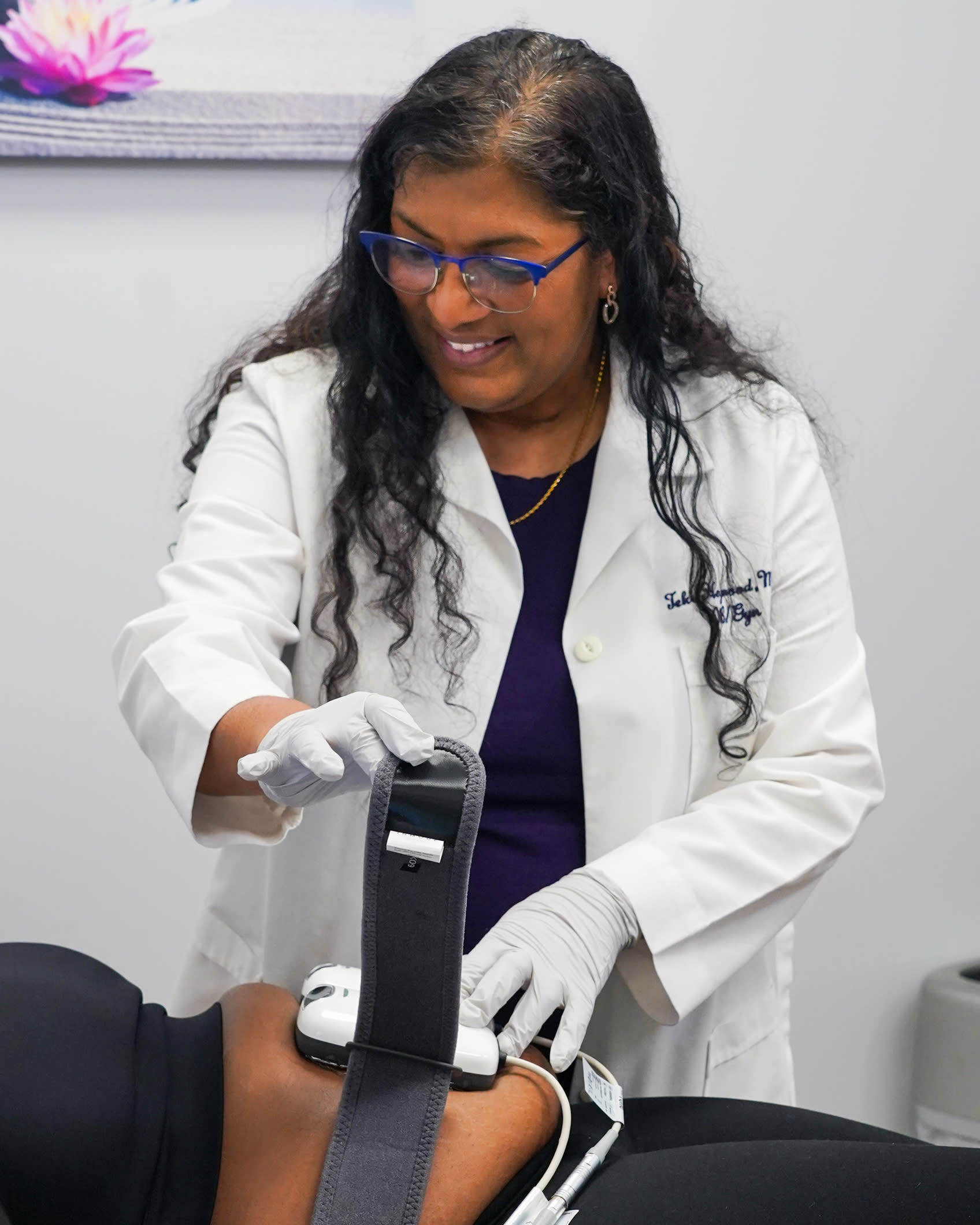 Doctor applying Empower RF Tone treatment to a woman at a med spa, to target skin tightening and muscle toning.