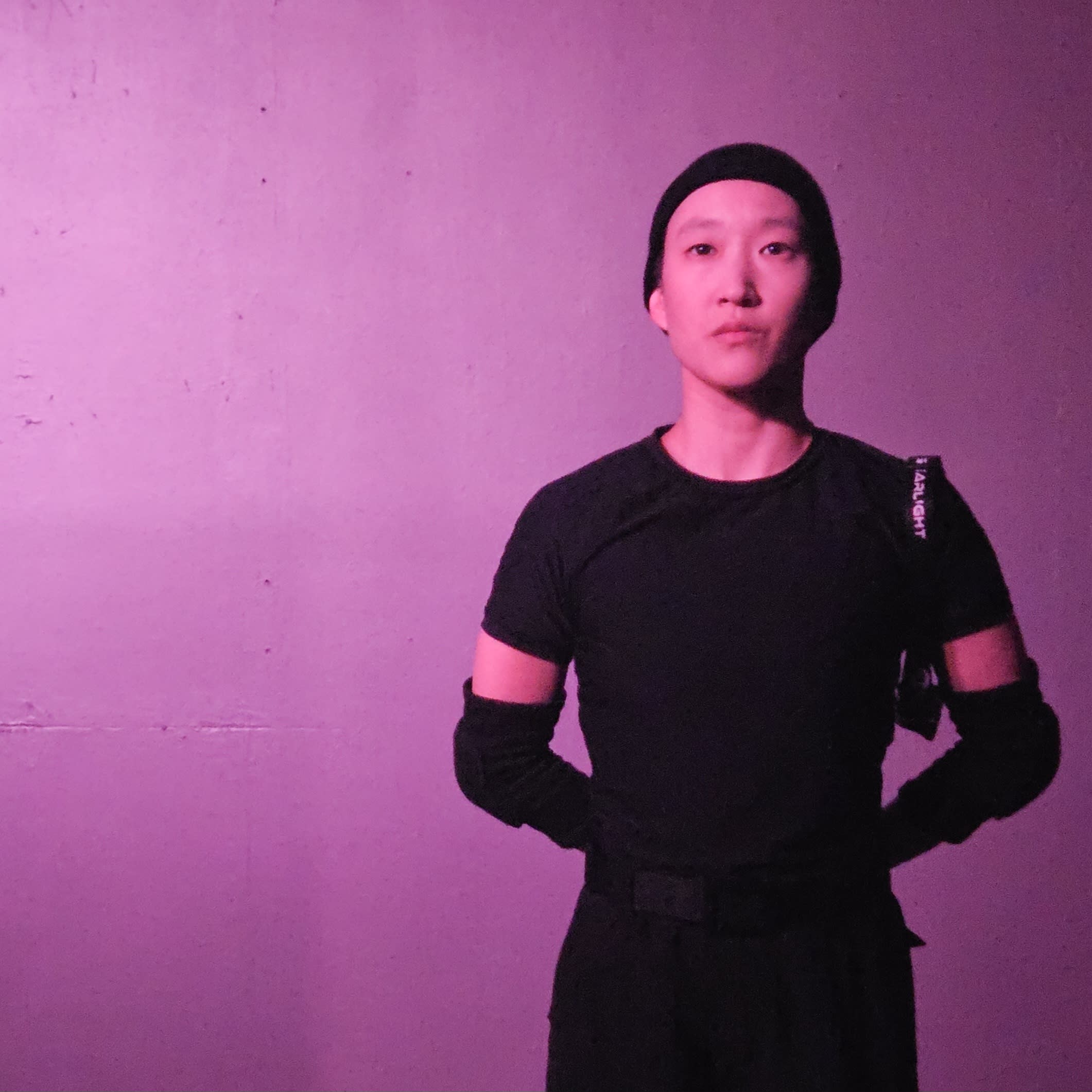 one actor is heist clothing standing in front of a purple wall