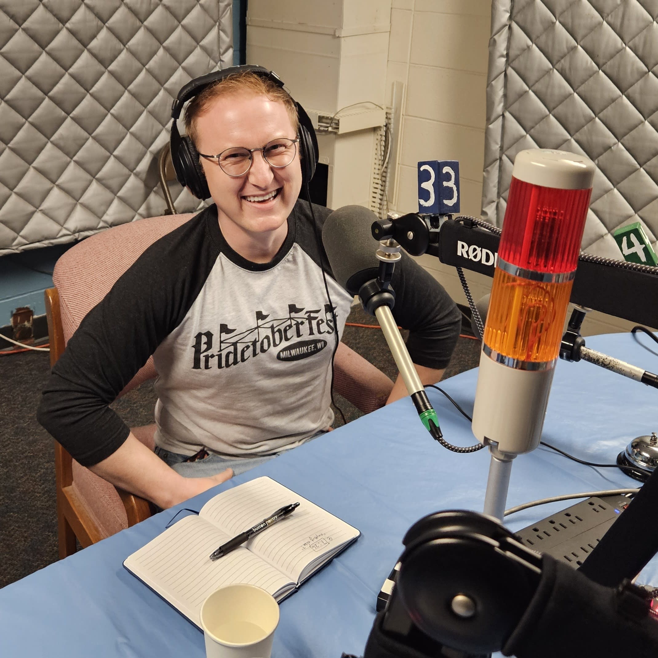 Vince wears headphone and sits in front of a microphone in a radio studio