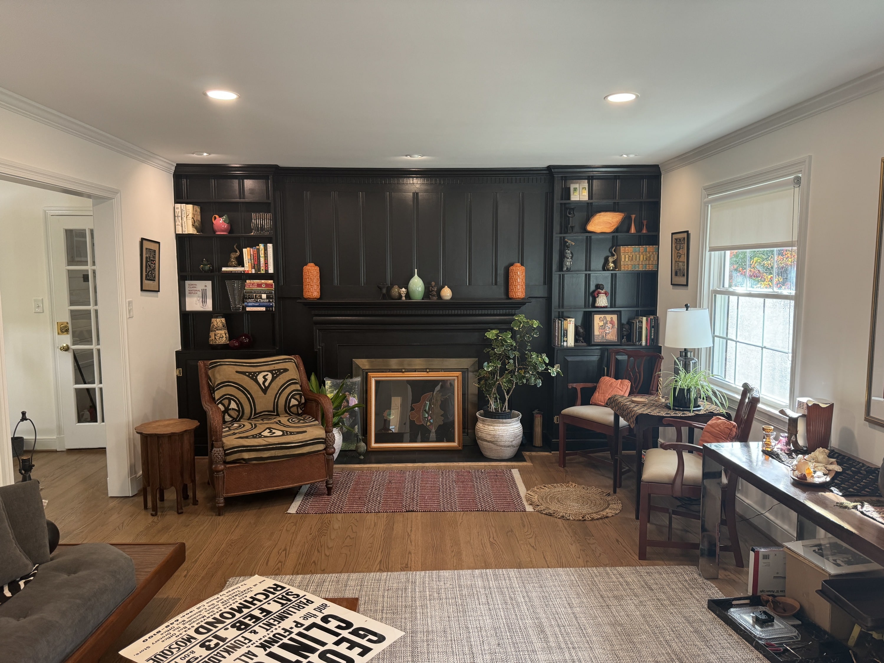 Living room with renovated fireplace surround, black custom built-ins, and recessed lighting.
